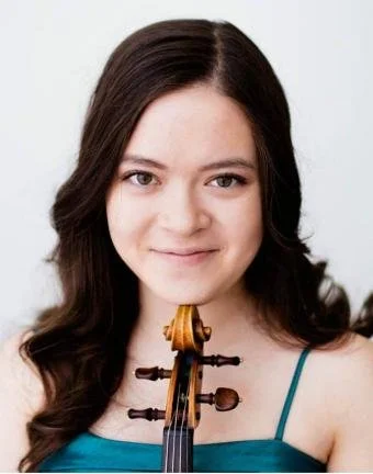 Young woman with long dark hair holding a violin in front of her chest
