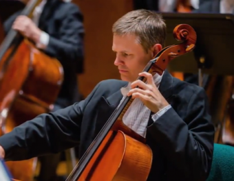 Musician playing a cello in an orchestra
