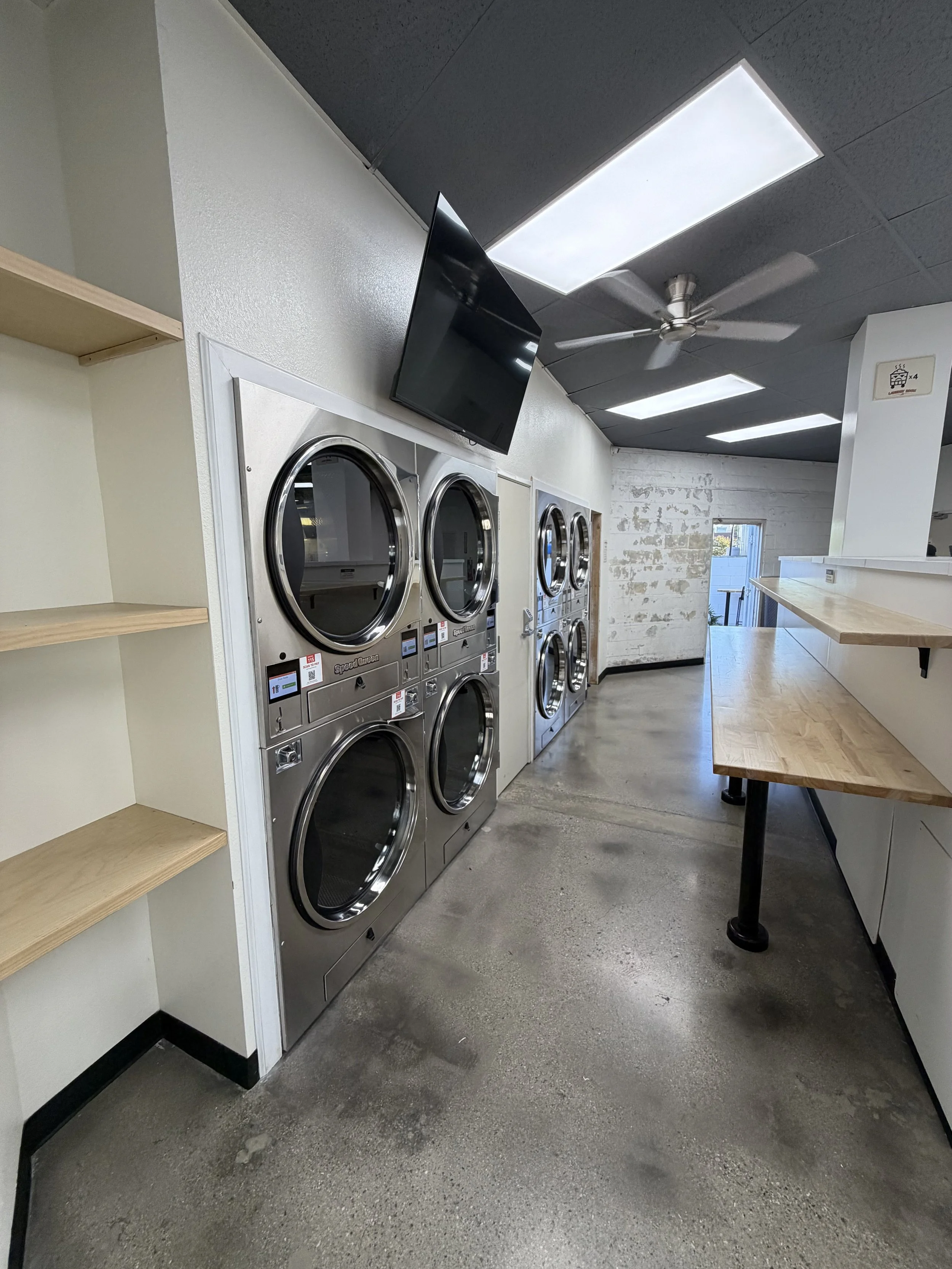 Stacked Speed Queen dryers and folding counter at Laundry Room LA