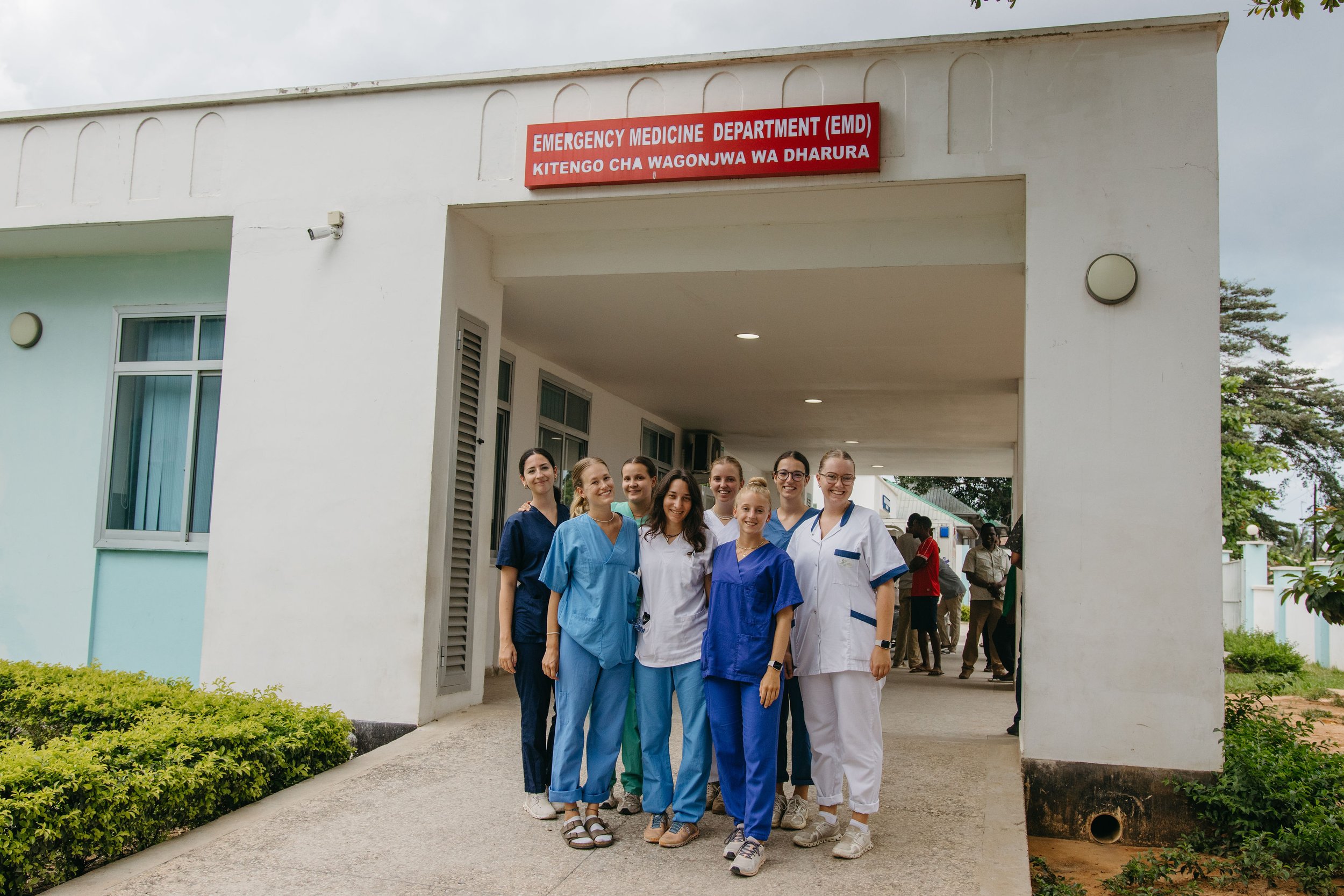 Group of nurses and healthcare workers standing outside the emergency medicine department at a hospital.