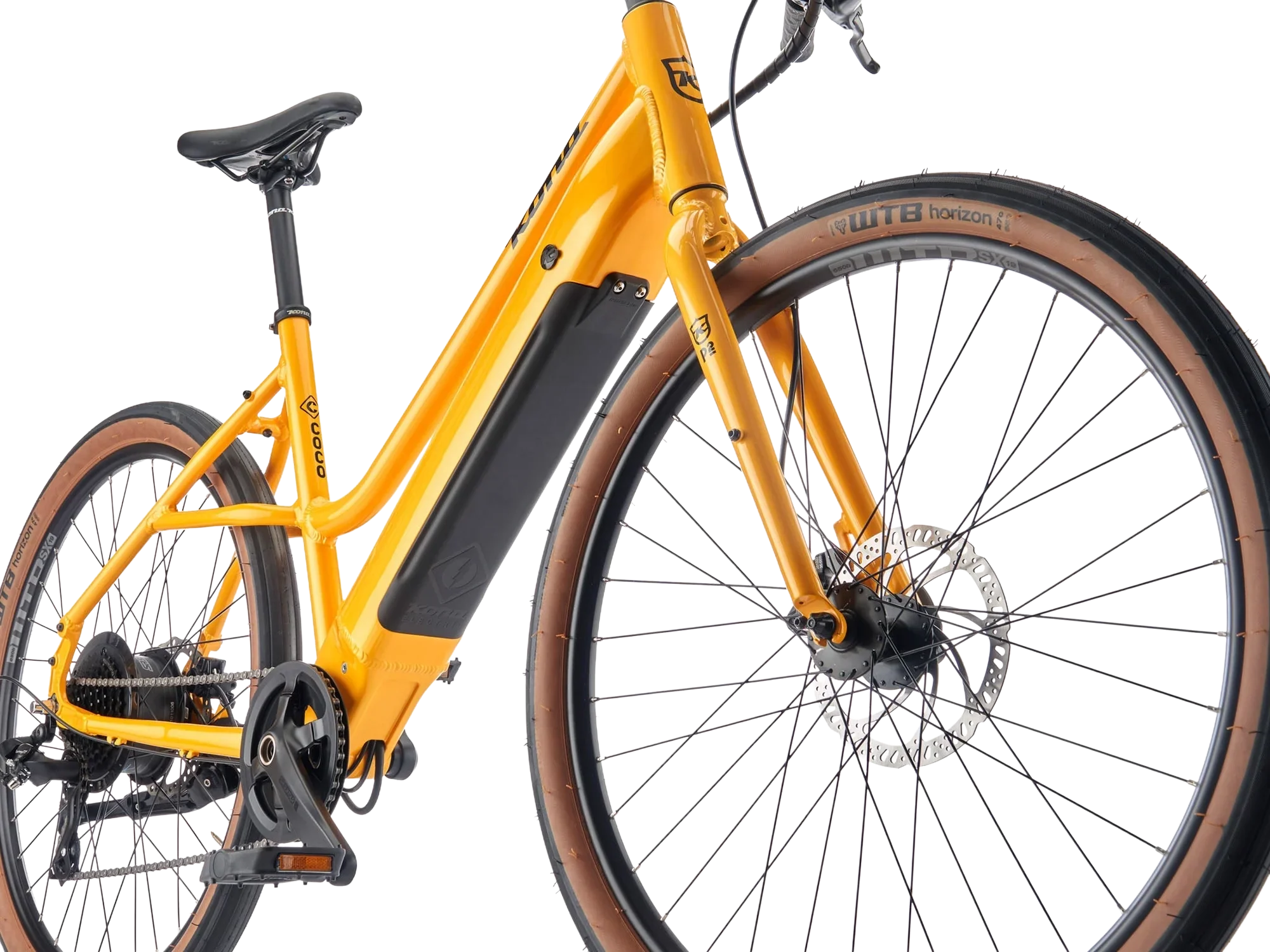 Close-up of a yellow electric mountain bike with black accents and brown tires, showing the frame, front and rear wheels, and part of the drivetrain.