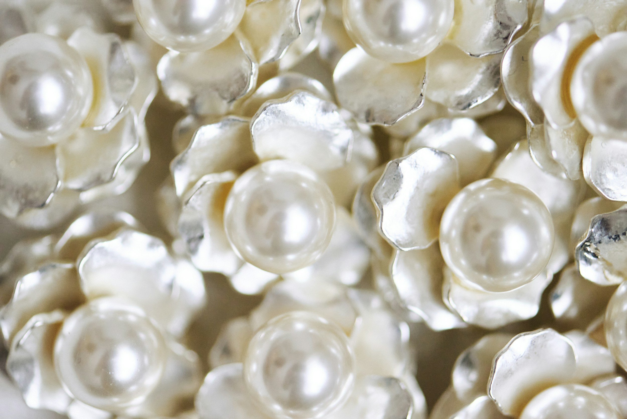 Close-up of numerous white pearls showing their smooth, shiny surfaces.