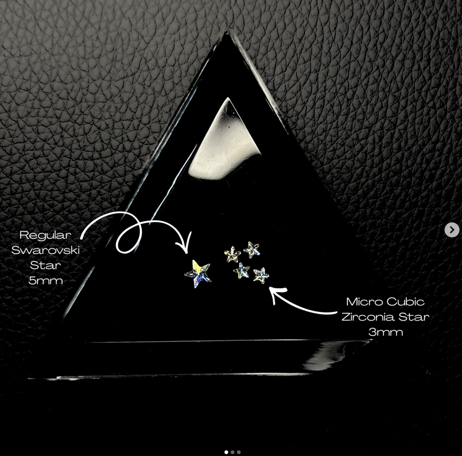 Display of small star-shaped Swarovski and zirconia crystals in various colors, on a black textured surface, with white text labels indicating their types and sizes: 'Regular Swarovski Star 5mm' and 'Micro Cubic Zirconia Star 3mm'.
