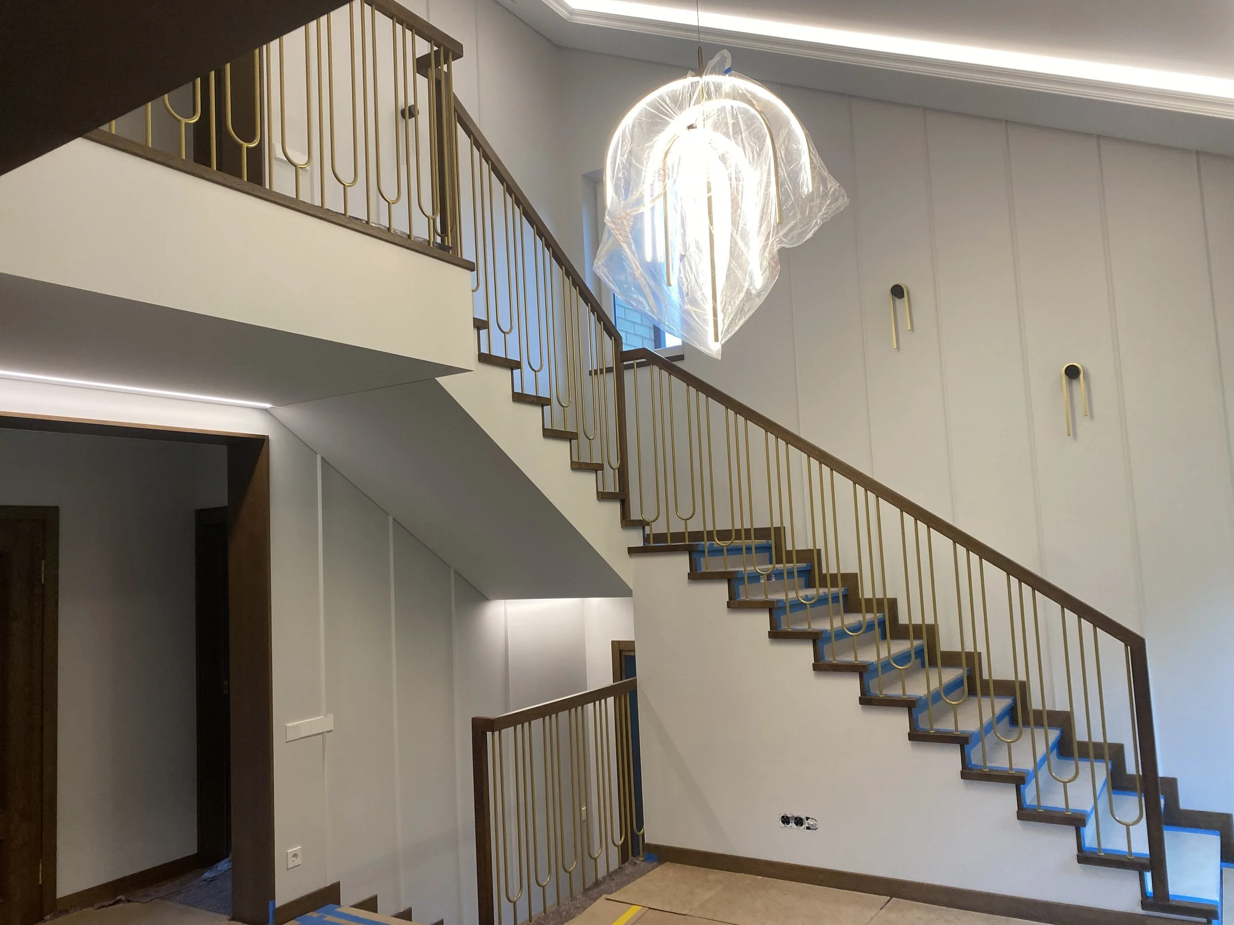 Šiuolaikinių laiptų su mediniais laipteliais, žalvariniais turėklais.