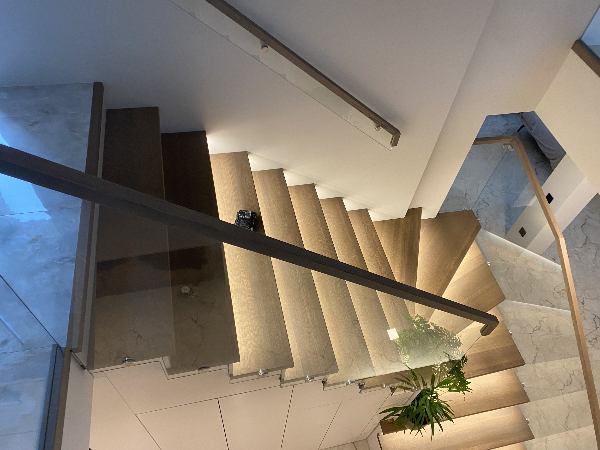 Šiuolaikinių laiptų su mediniais laipteliais, stikliniais turėklais.