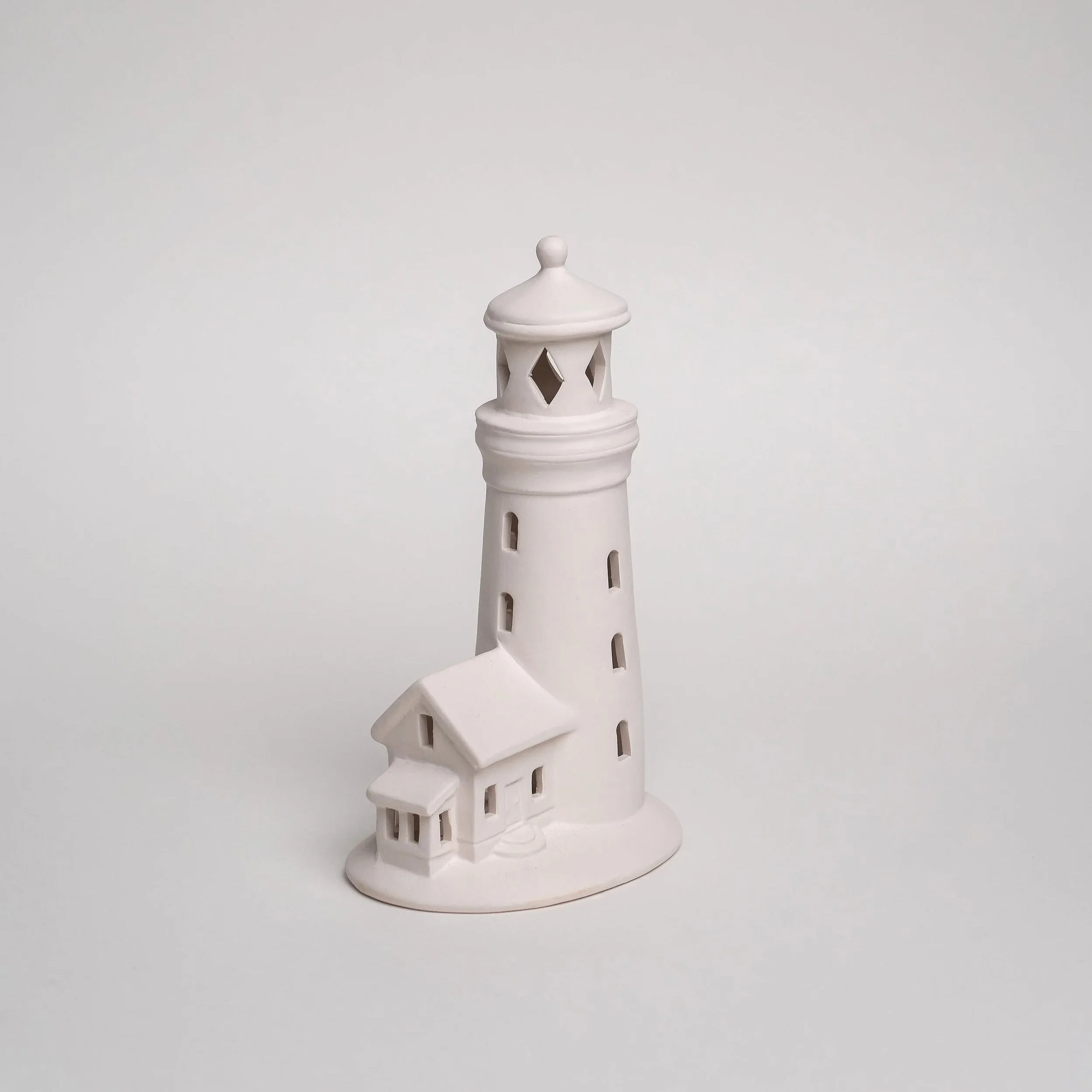 Hvid miniature tårn med vinduer og kuppel mod en neutral baggrund.