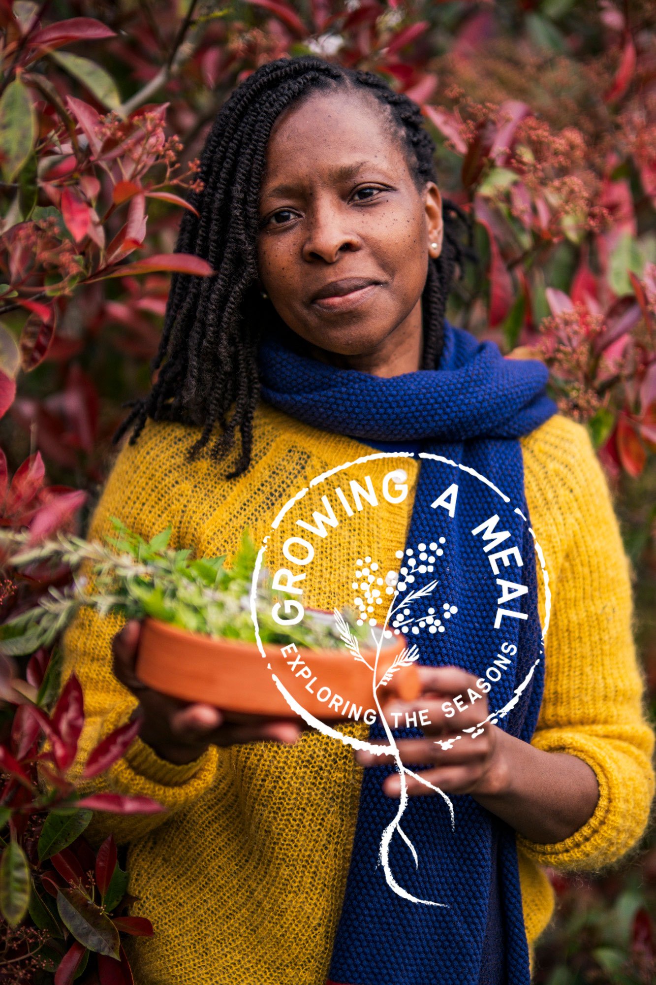 Een vrouw in een gele trui en een blauwe sjaal houdt een pot met groene planten vast, omringd door roze en groene bladeren.