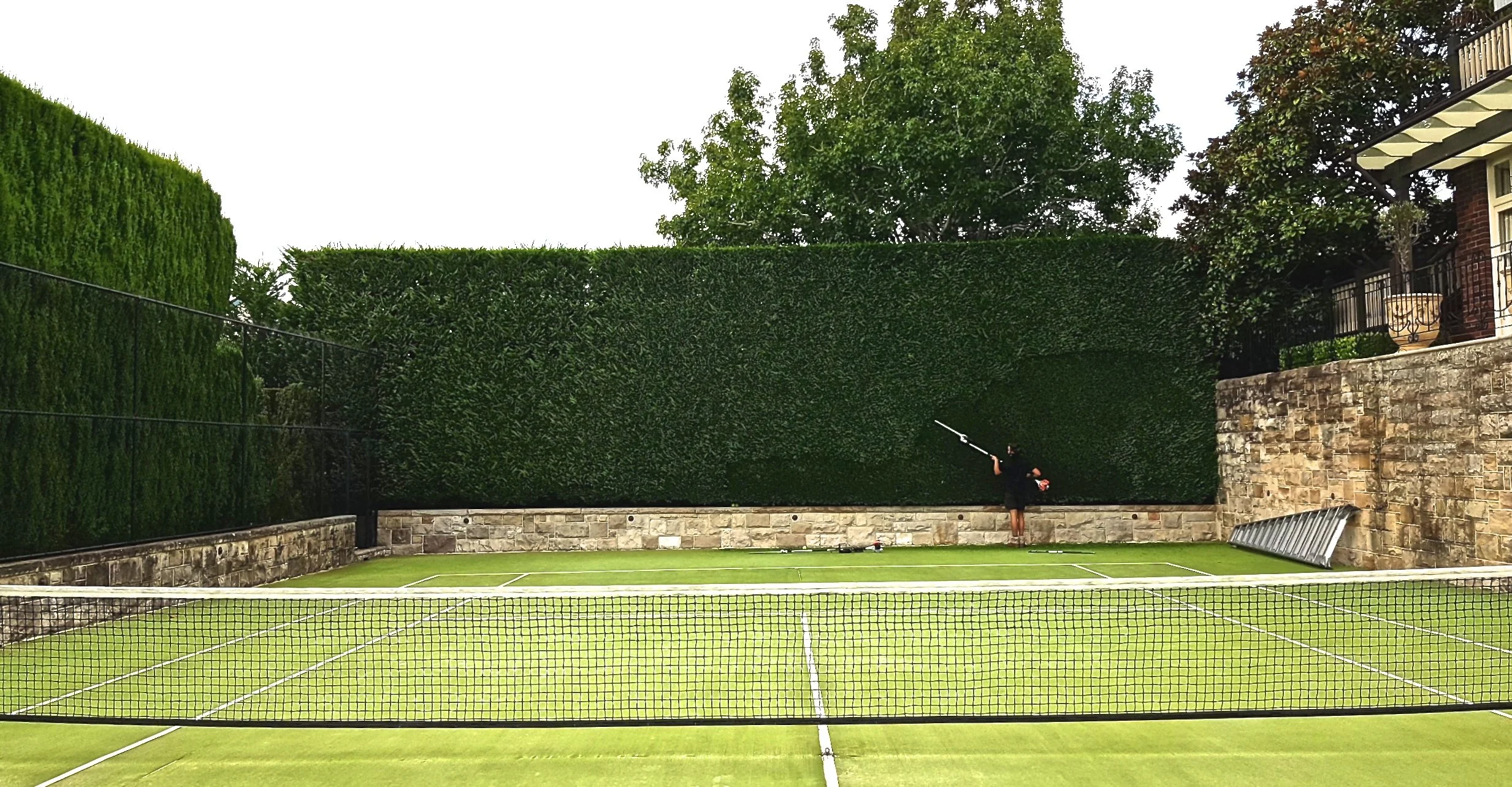 me cutting tennis court hedge.jpg