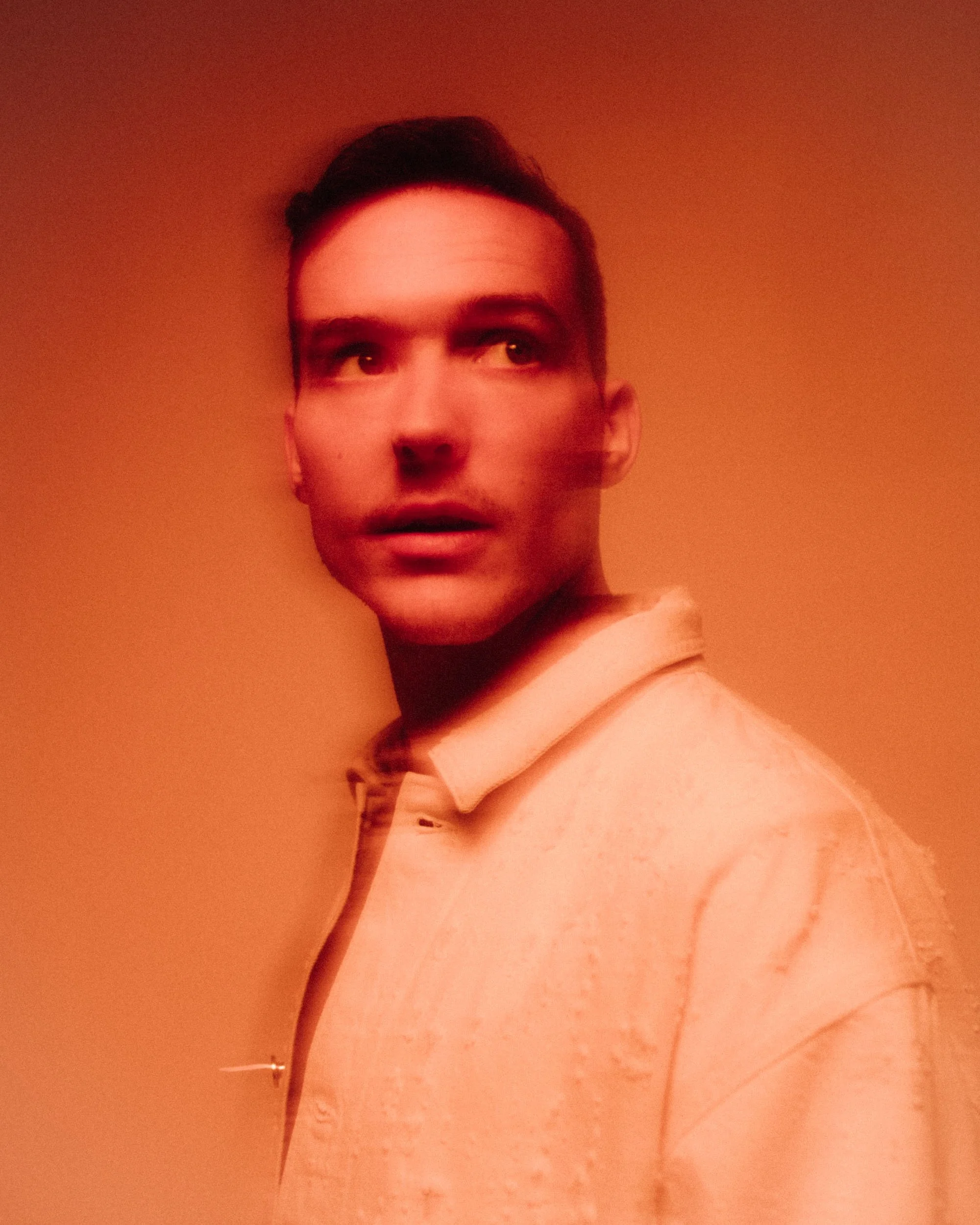 Close-up red studio portrait of Ben Böhmer photographed by Dan Medhurst for Ninja Tune.