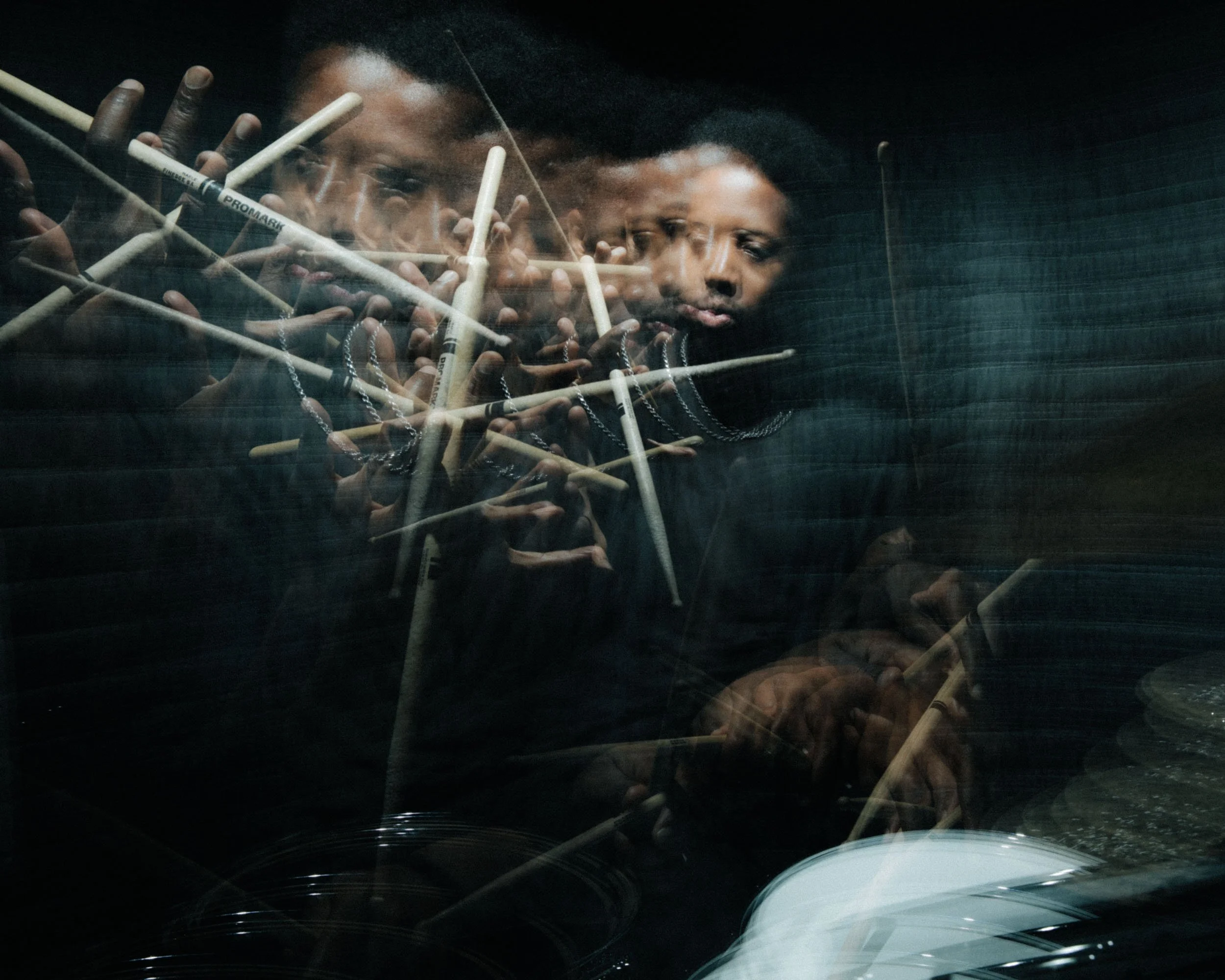 A reflection of two children pressing their hands and faces against a glass window, with a dark background.