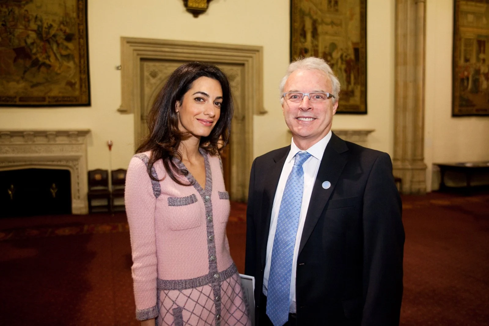 A woman and a man in formal attire standing in a decorated room.