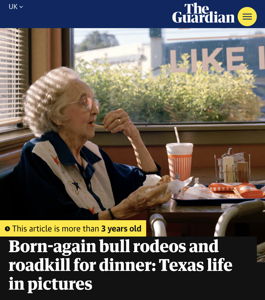 An elderly woman with white hair and glasses sitting in a diner, enjoying a meal with a soft drink and fries, with a window behind her showing greenery and a sign that says 'LIKE'.