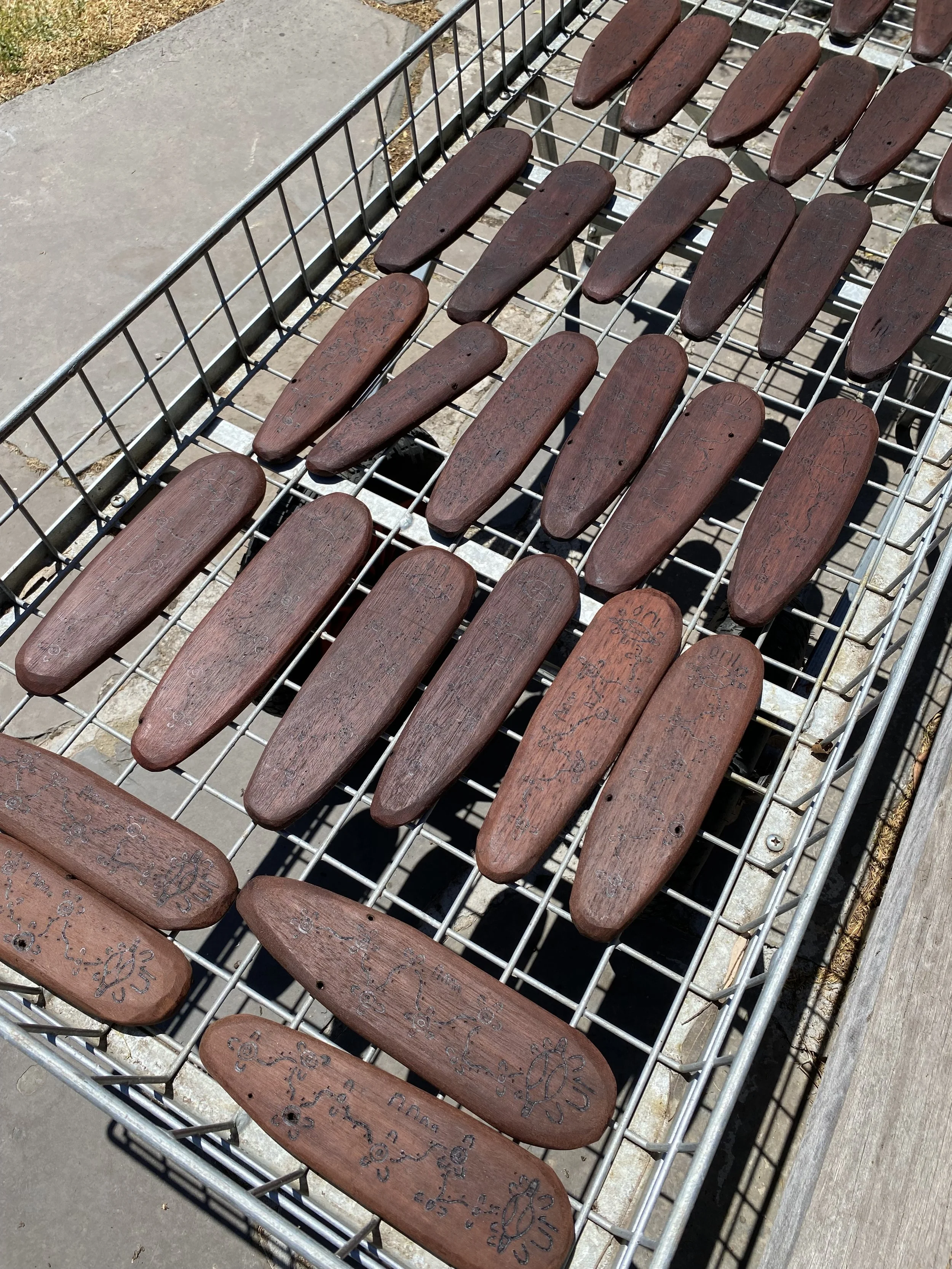 Engraved wooden message sticks laying on a wire cart.