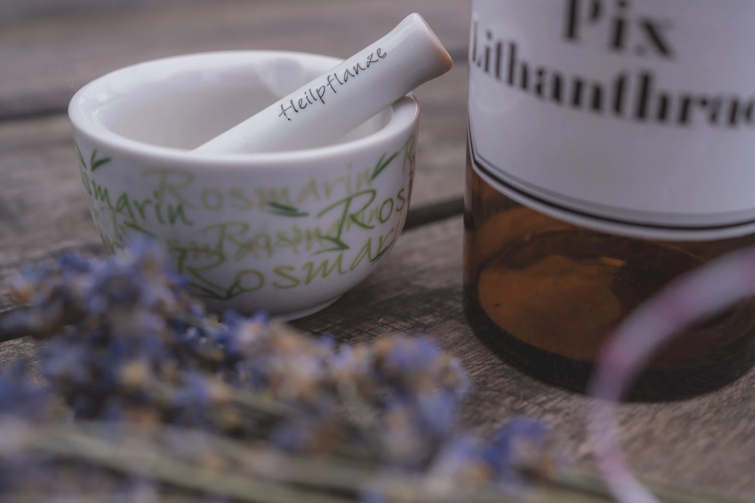 Eine weiße Keramikschale und ein angebrachtes Kräuterstängel mit dem Label 'Heilpflanze'.