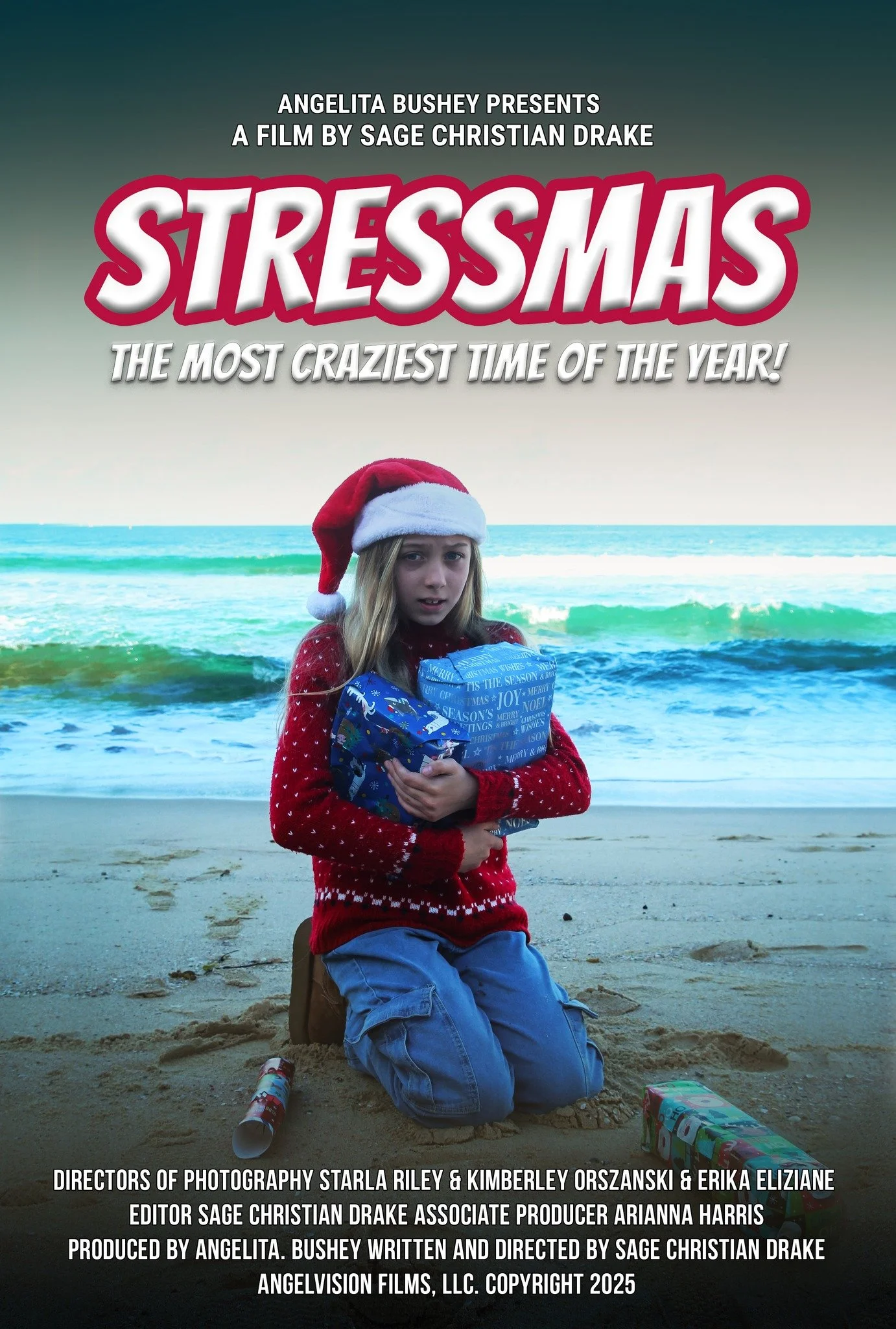 A young girl wearing a red Christmas sweater and Santa hat kneeling on a beach, holding a wrapped Christmas gift, with Christmas wrapping paper scattered on the sand and a blue ocean in the background.