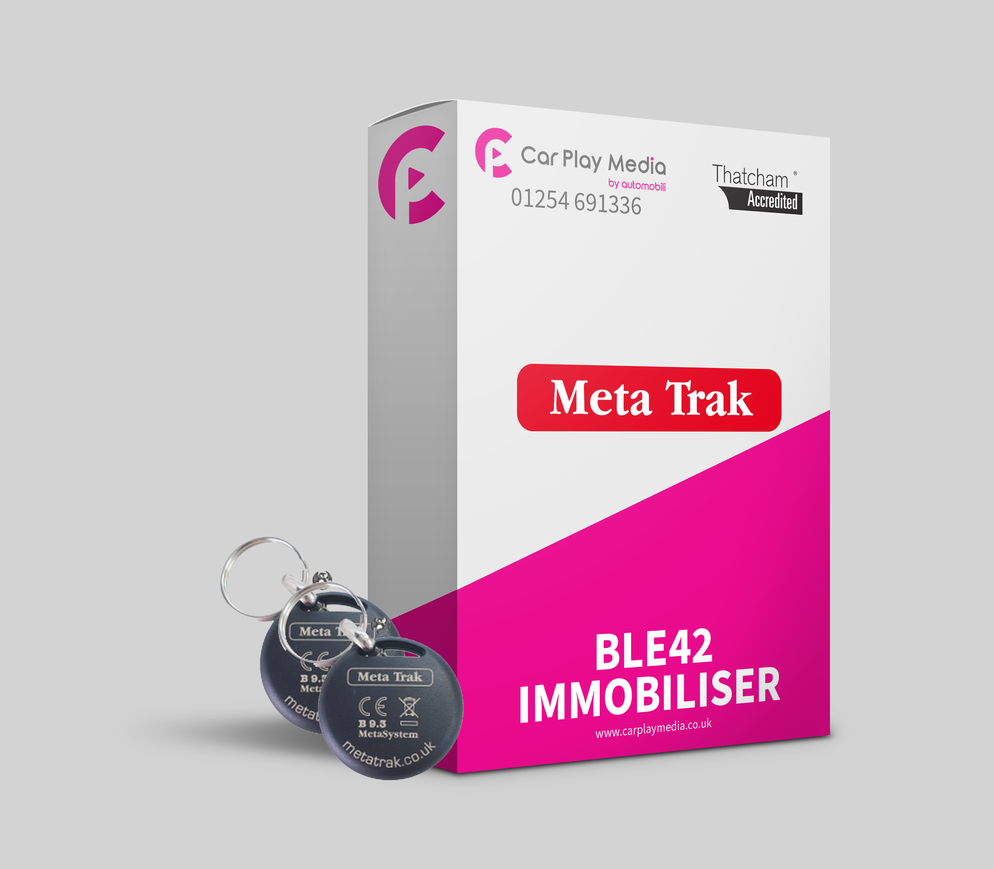 A product display box for Meta Trak vehicle immobilizer and tracking system with key fobs attached, and the brand logo and contact details visible.