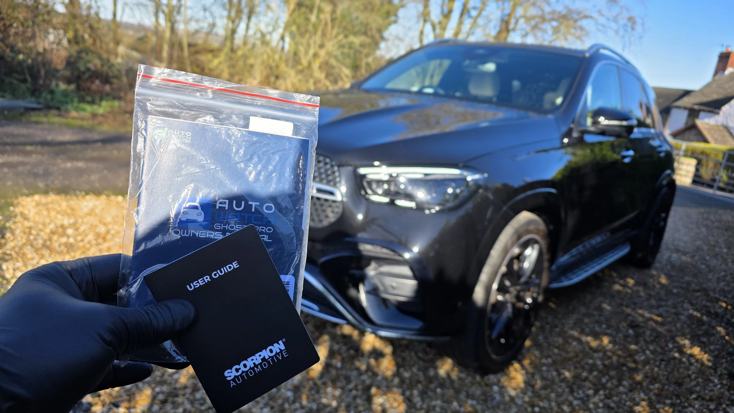 ScorpionTrack vehicle security system ready for installation on a black Mercedes