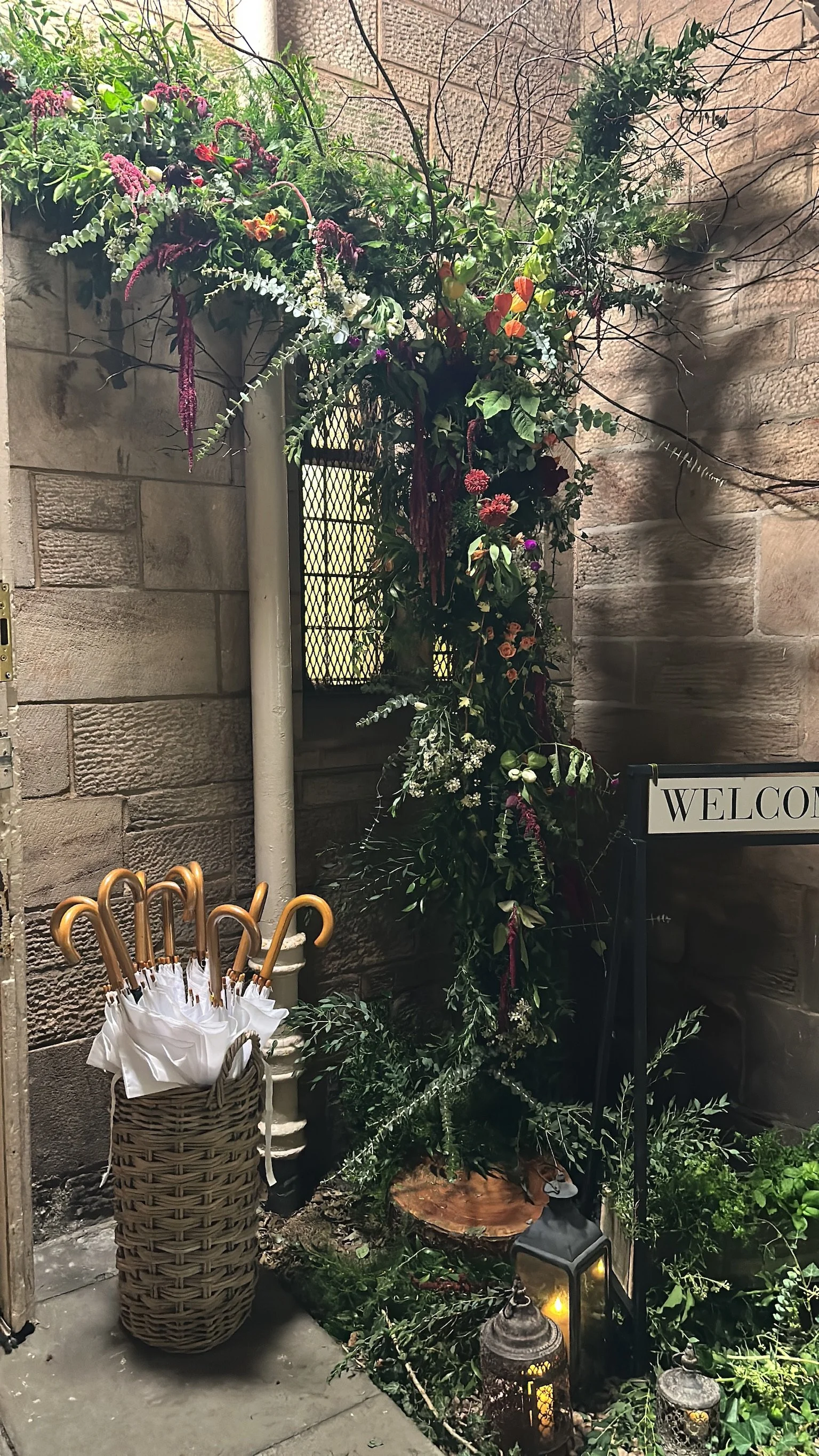 A decorative floral arrangement with various green leaves and flowers, displayed next to a