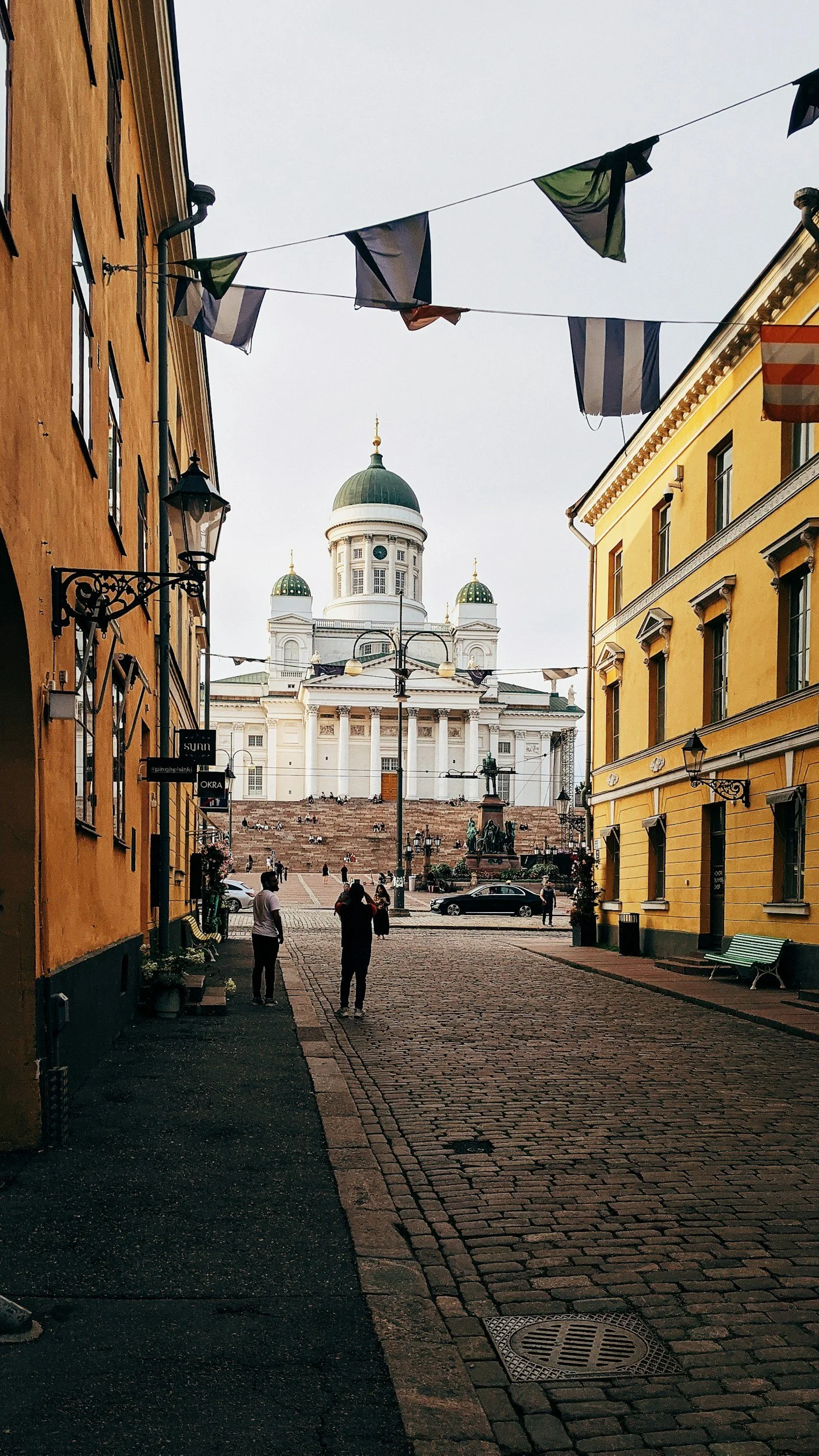 Helsinki Cathedral viewed along a cobbled street lined with colourful historic buildings in central Helsinki, Finland.