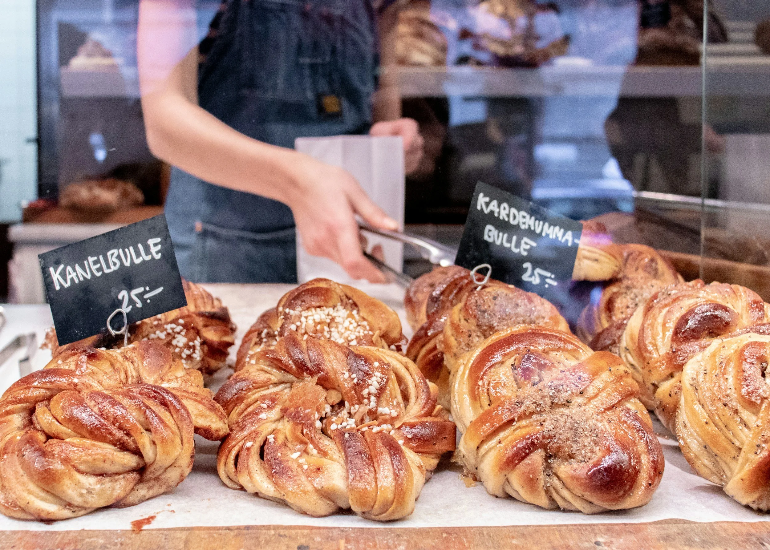 Freshly baked Swedish cinnamon and cardamom buns displayed at a traditional bakery counter.