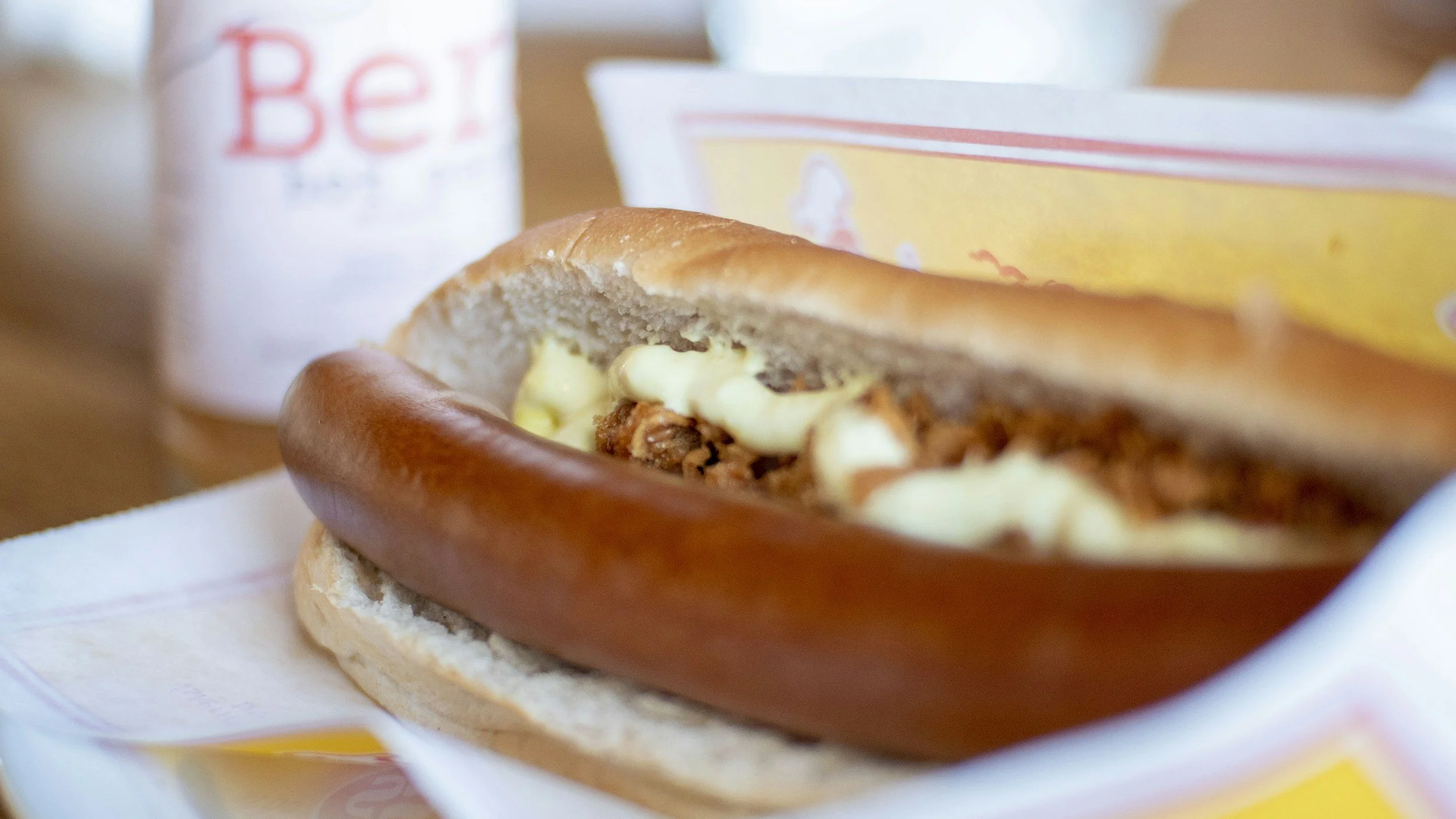 An Icelandic hot dog served in a soft bun with sauce and crispy onions.