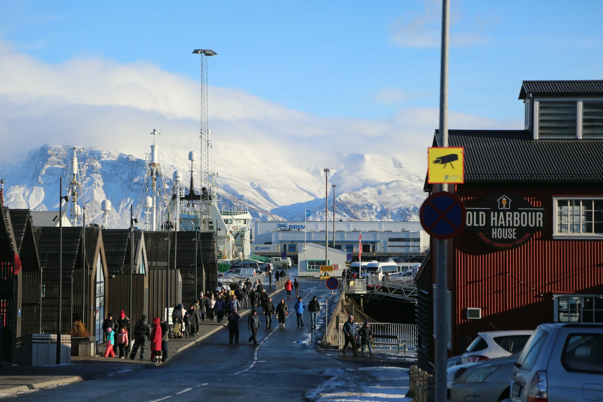 Reykjavík Old Harbour with fishing boats, waterfront buildings and snow-covered mountains beyond.