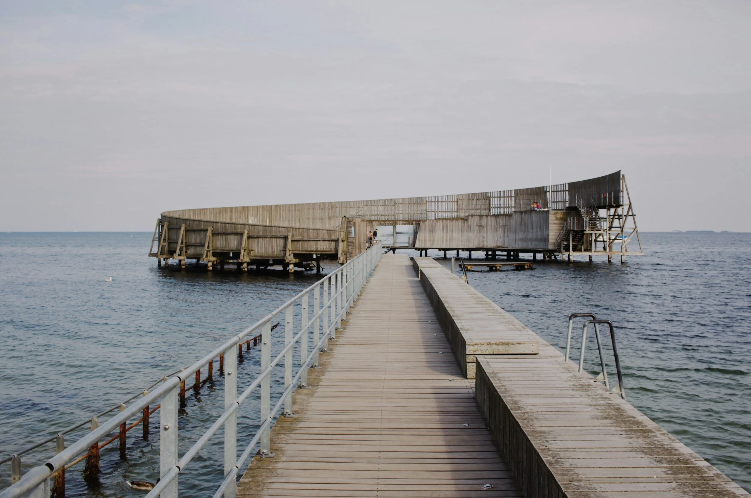 A wooden walkway leads across the sea to Kastrup Sea Bath near Copenhagen, Denmark.