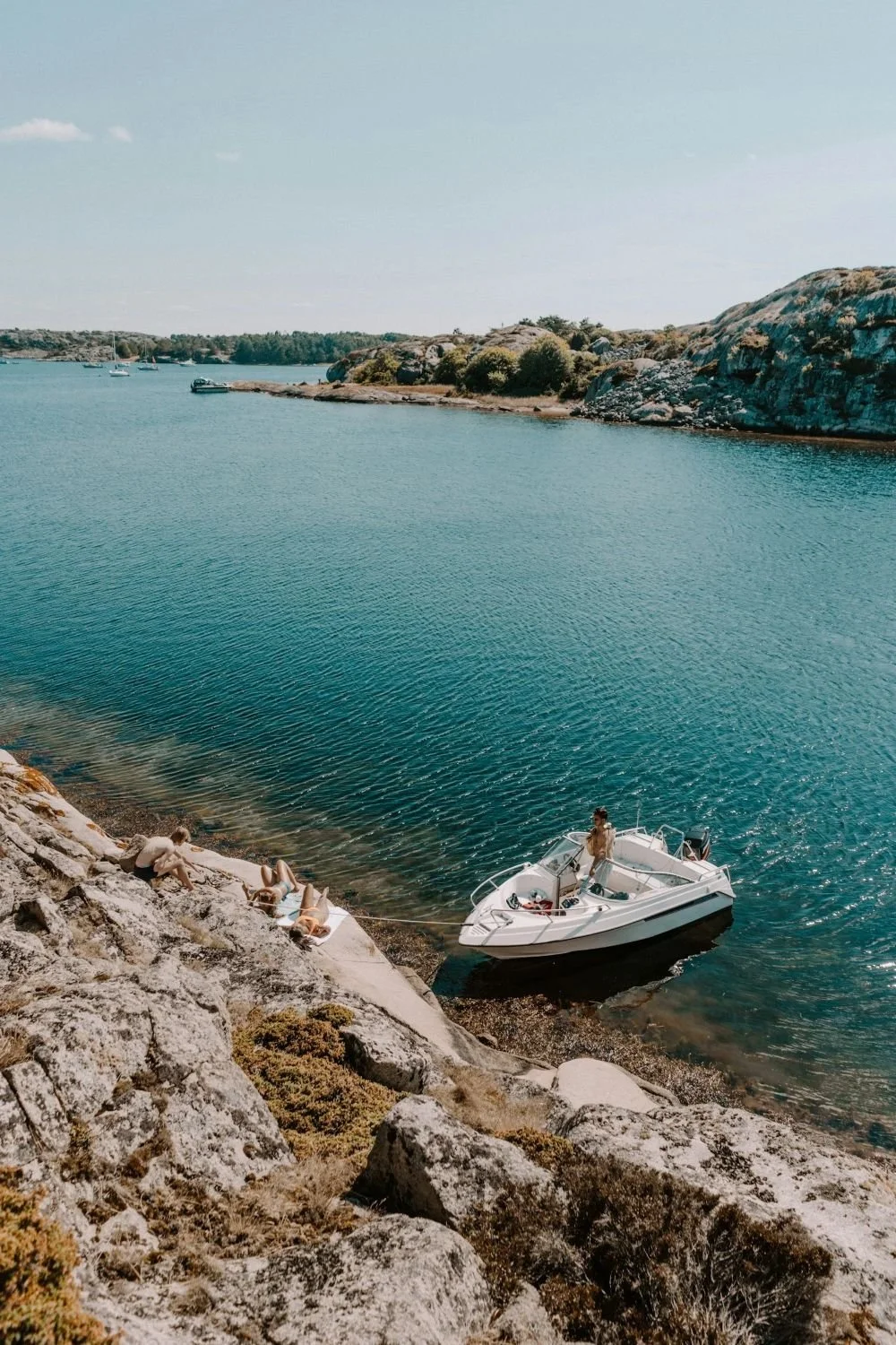 A small motorboat rests beside rocky islands and clear blue water near Grebbestad on Sweden’s west coast.