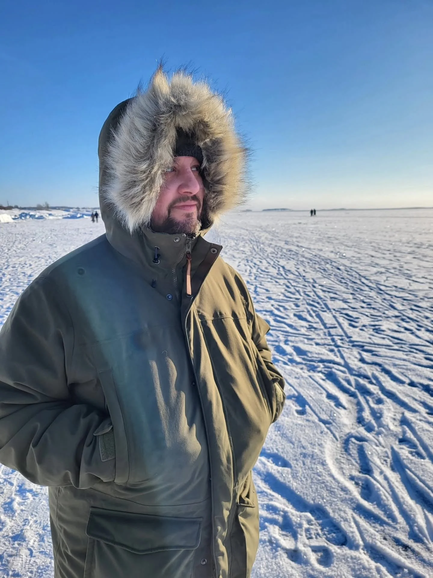 A man standing in a winter coat on a frozen section of the Baltic sea off the coast of Helsinki