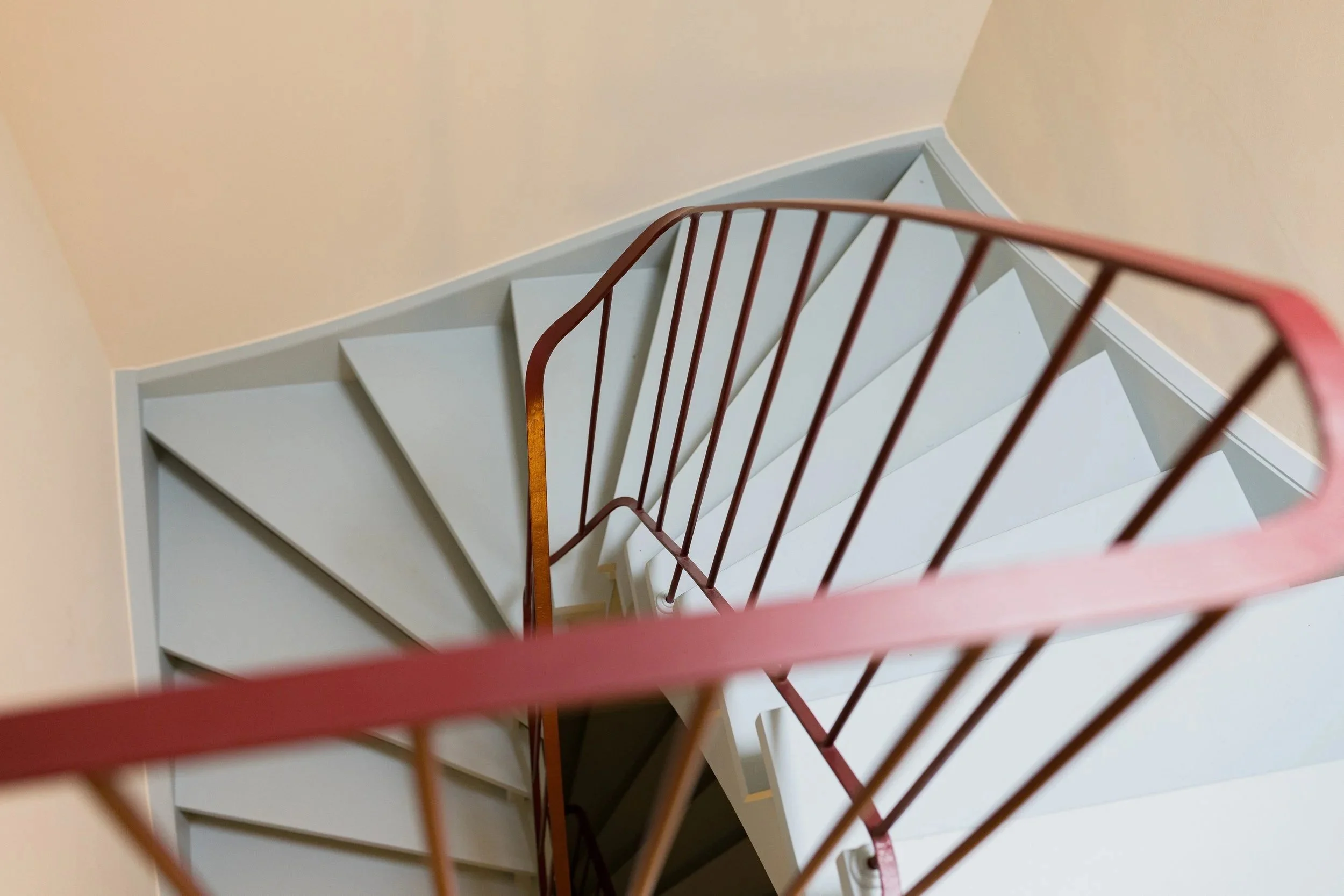 Farrow & Ball Preference Red setzt am Treppengeländer einen kräftigen Farbakzent und betont die geschwungene Form der bestehenden Treppe.