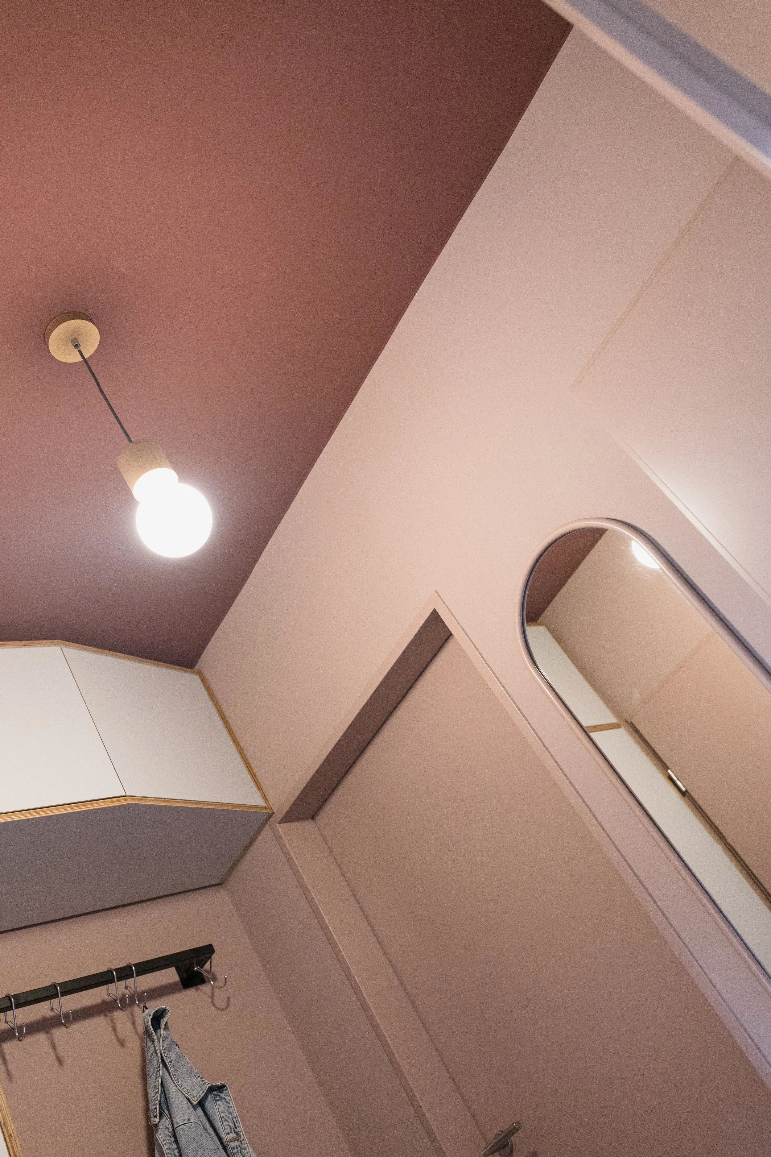 Colour Drench im Entrée mit Farrow & Ball Sulking Room Pink an den Wänden – die intensive Farbgestaltung bindet den bestehenden Einbau und die Sitzbank selbstverständlich in das neue Raumkonzept ein.