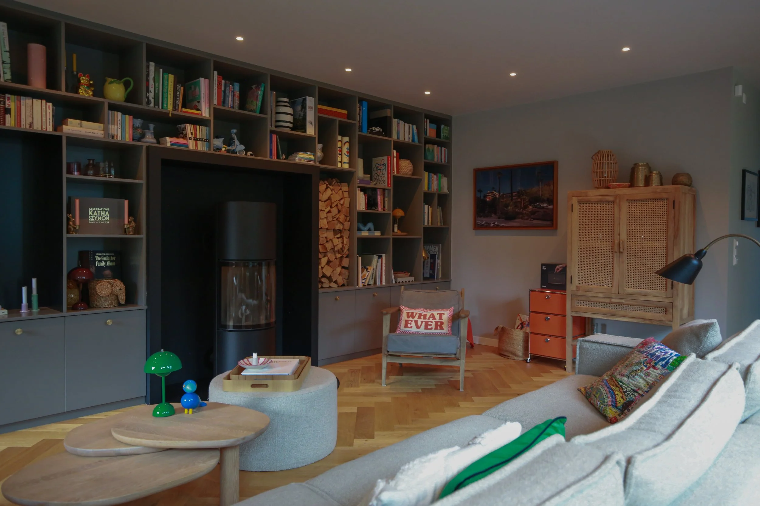 Maßgefertigte Wohnwand mit Regal, Stauraum und integriertem Kamin in einem individuell gestalteten Wohnzimmer in Hamburg.