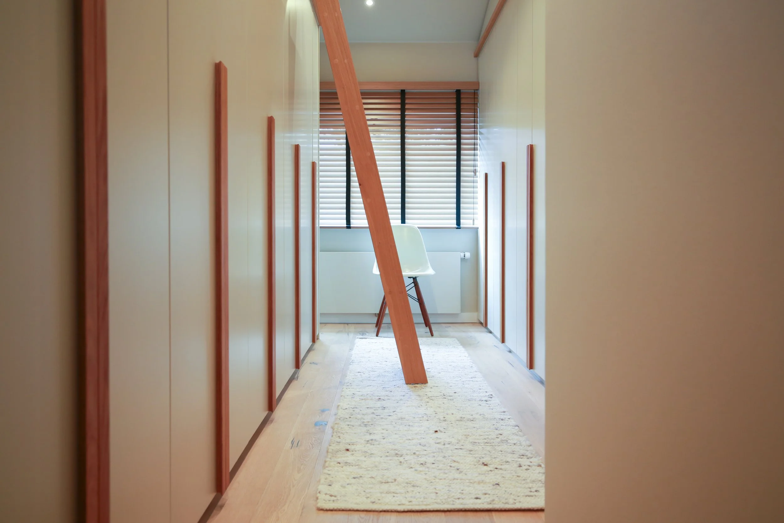 Maßgefertigte Einbauschränke mit Holzdetails und integriertem Stauraum im Obergeschoss eines Architektenhauses in Hamburg.