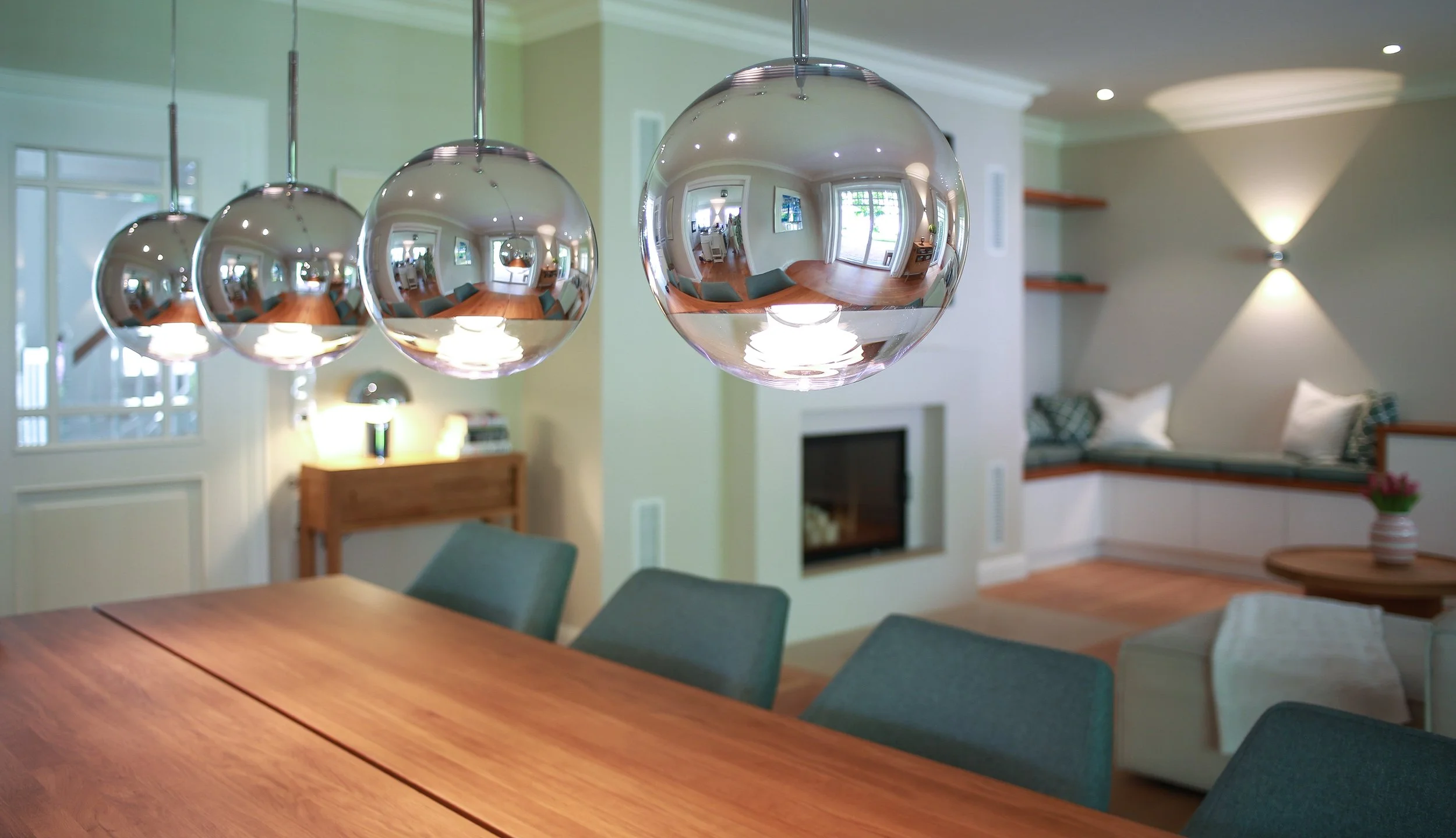 Essbereich mit skulpturalen Pendelleuchten, Holztisch und Blick in den Wohnraum – ganzheitliches Interior Design für ein Familienhaus in Hamburg.