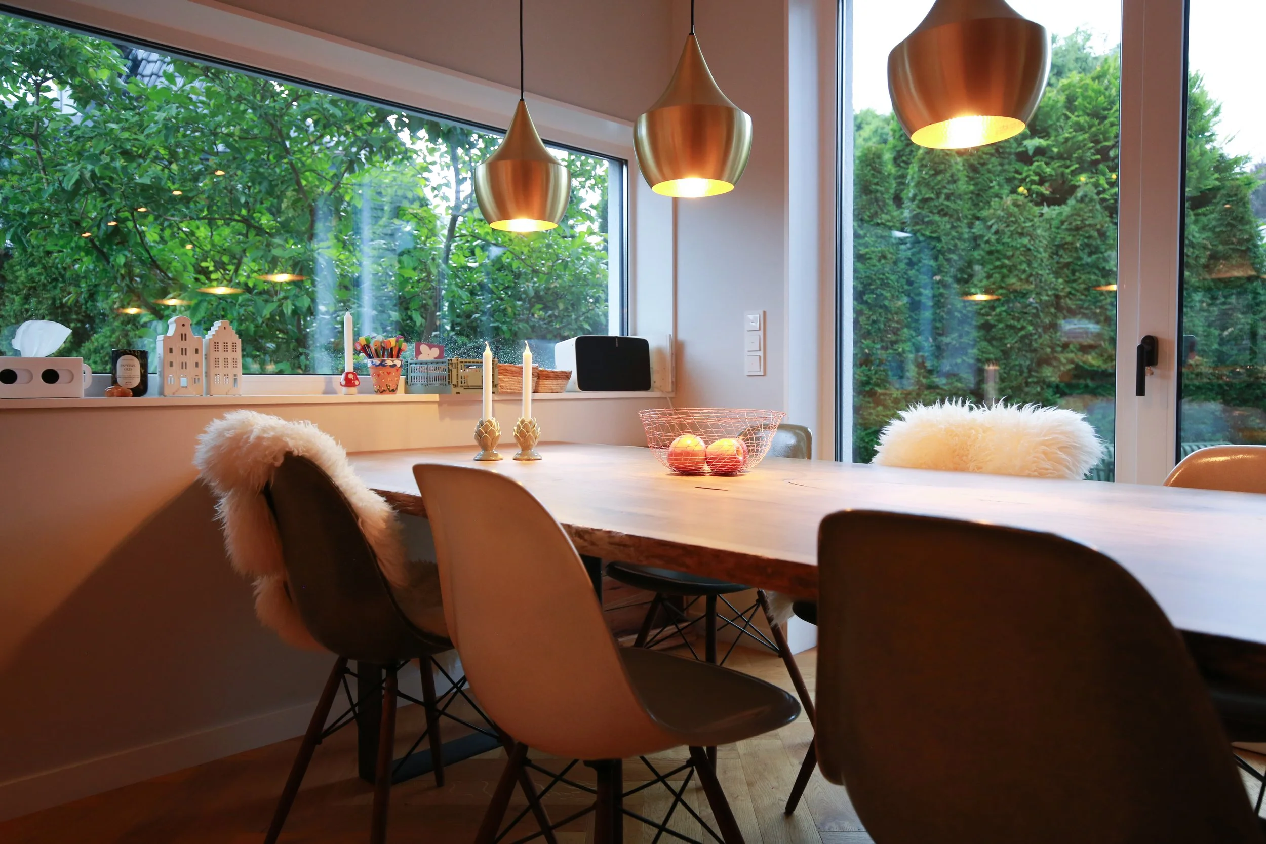 Essbereich mit Vintage Eames Chairs von Vitra und Pendelleuchten von Tom Dixon – Designklassiker treffen auf warme Materialien und ein zurückhaltendes Farbkonzept.