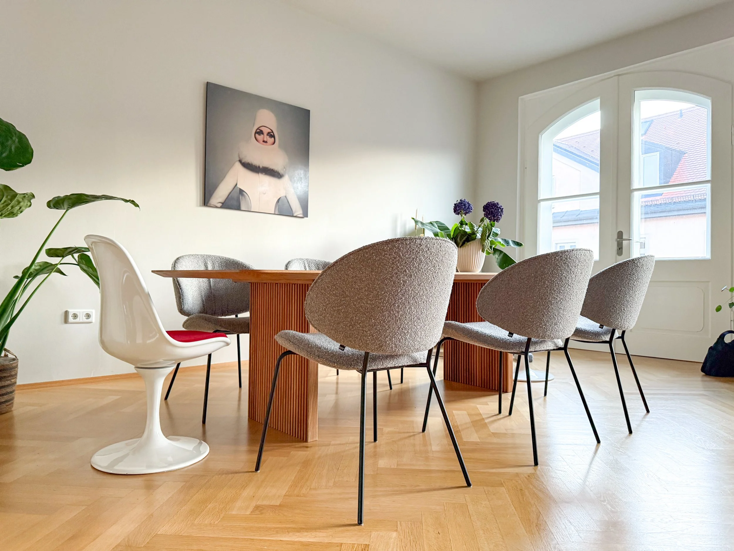 Esszimmer im Münchner Altbau mit Fischgrätparkett, Designmöbeln und Kunst – ein Mix aus klassischen und modernen Elementen.