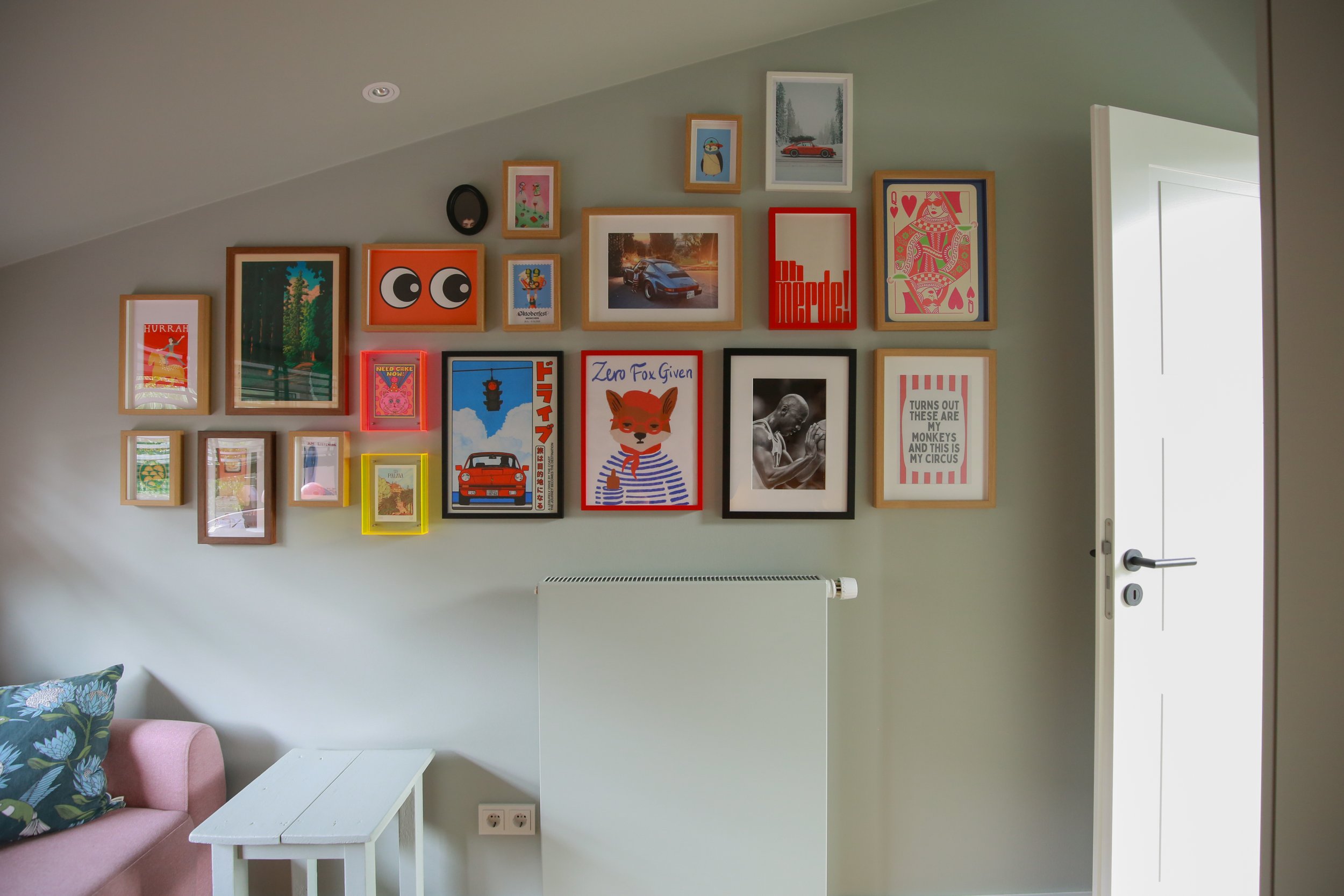 Individuelle Bilderwand mit farbigen Prints, abgestimmtem Farbkonzept und maßgefertigten Einbauten in Hamburg.