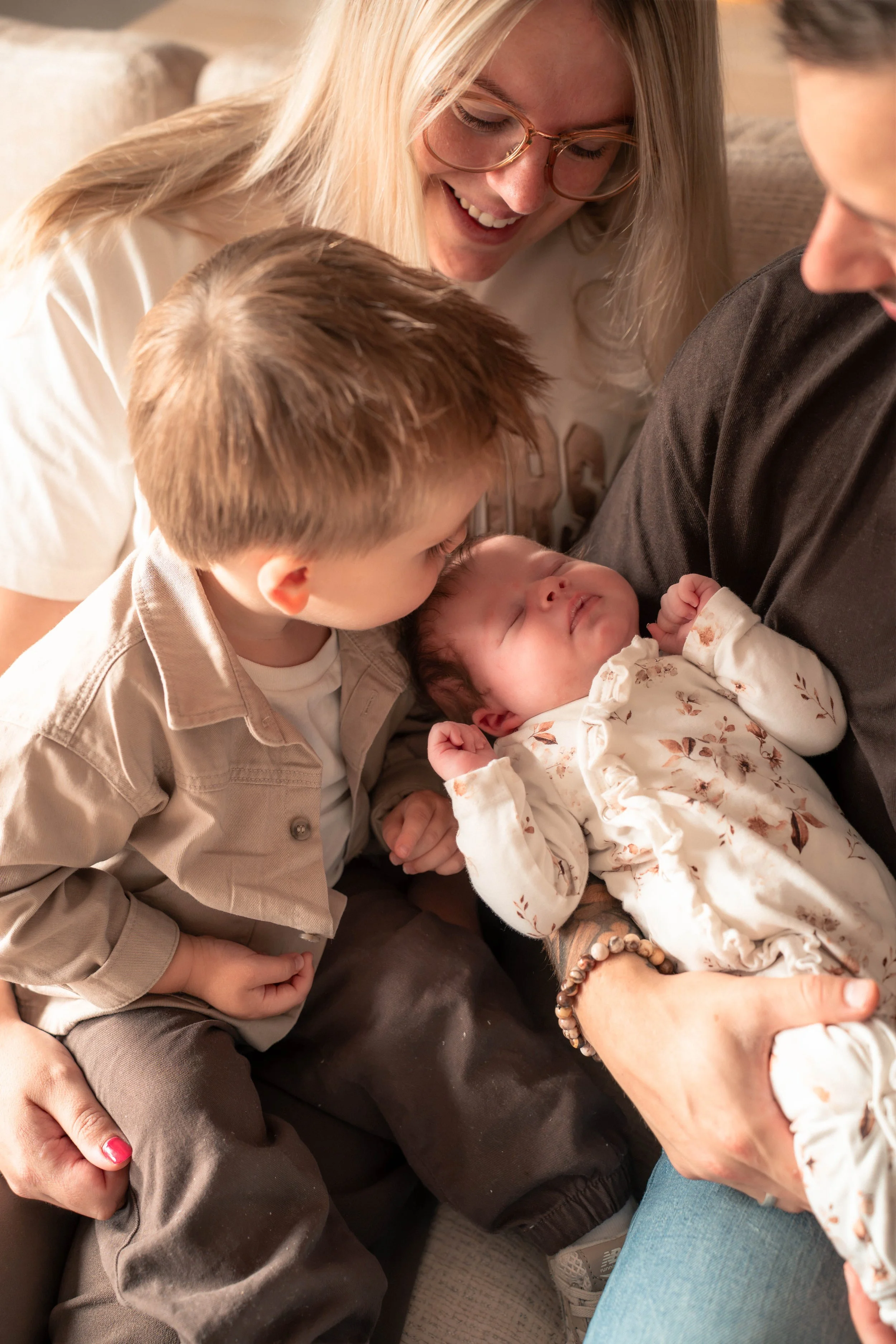 Een familie die samen knuffelt met een pasgeboren baby.