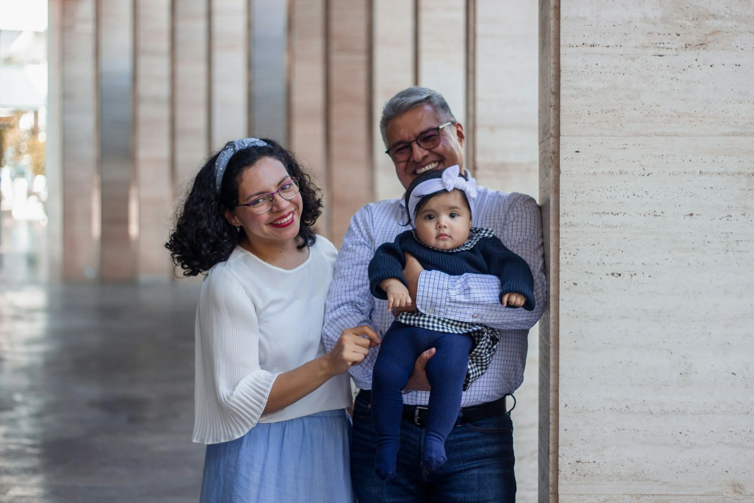 Grandparents hold their grandbaby.