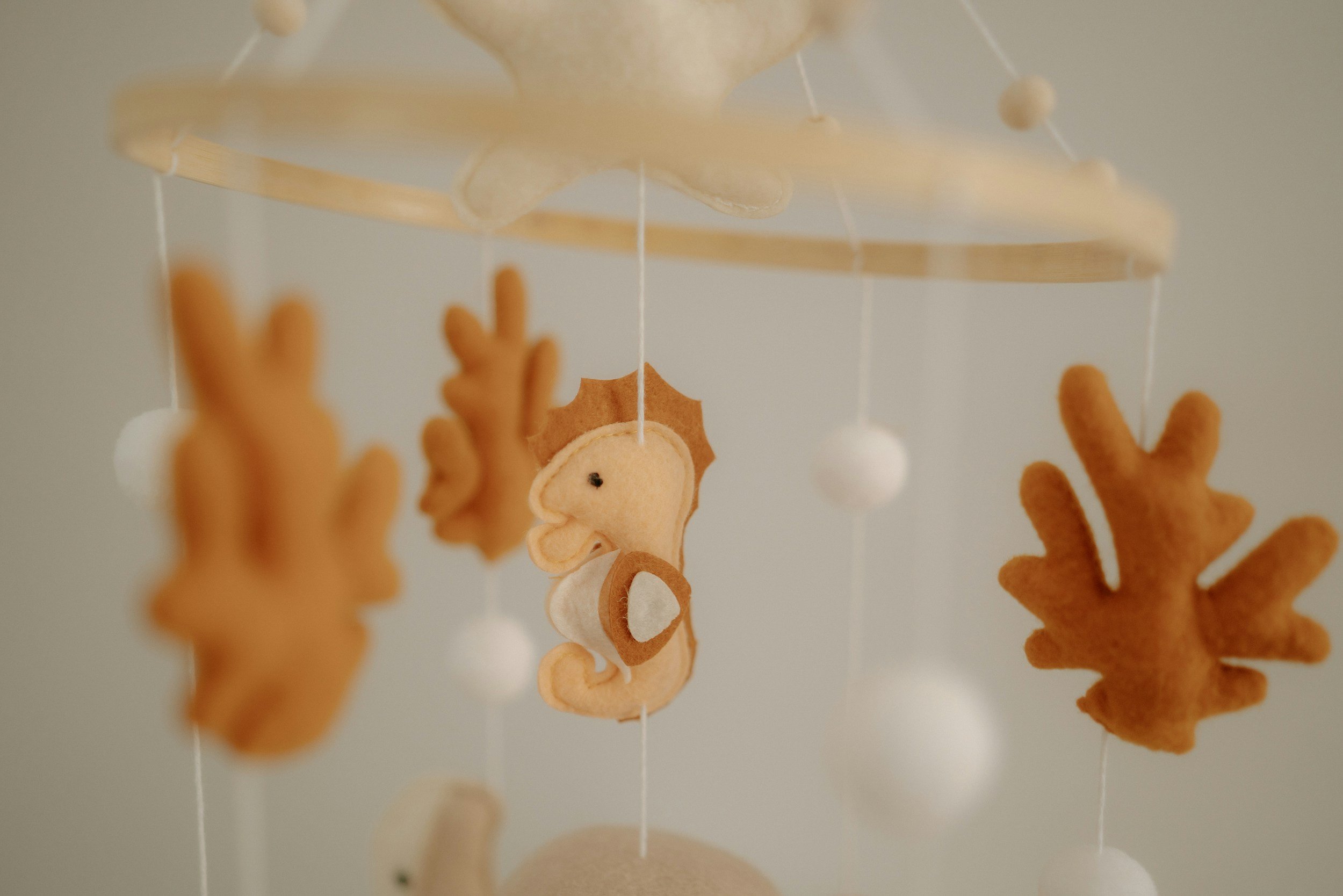 A baby mobile hangs over a crib. A postpartum doula can help a family prepare for baby's arrival.