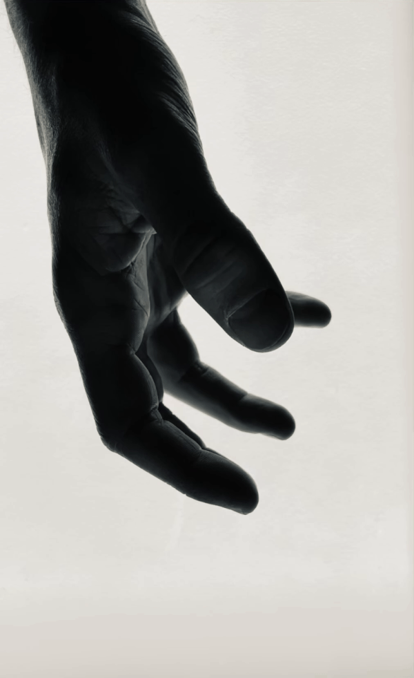 Close-up of a person's hand with fingers slightly curled, photographed against a light background.