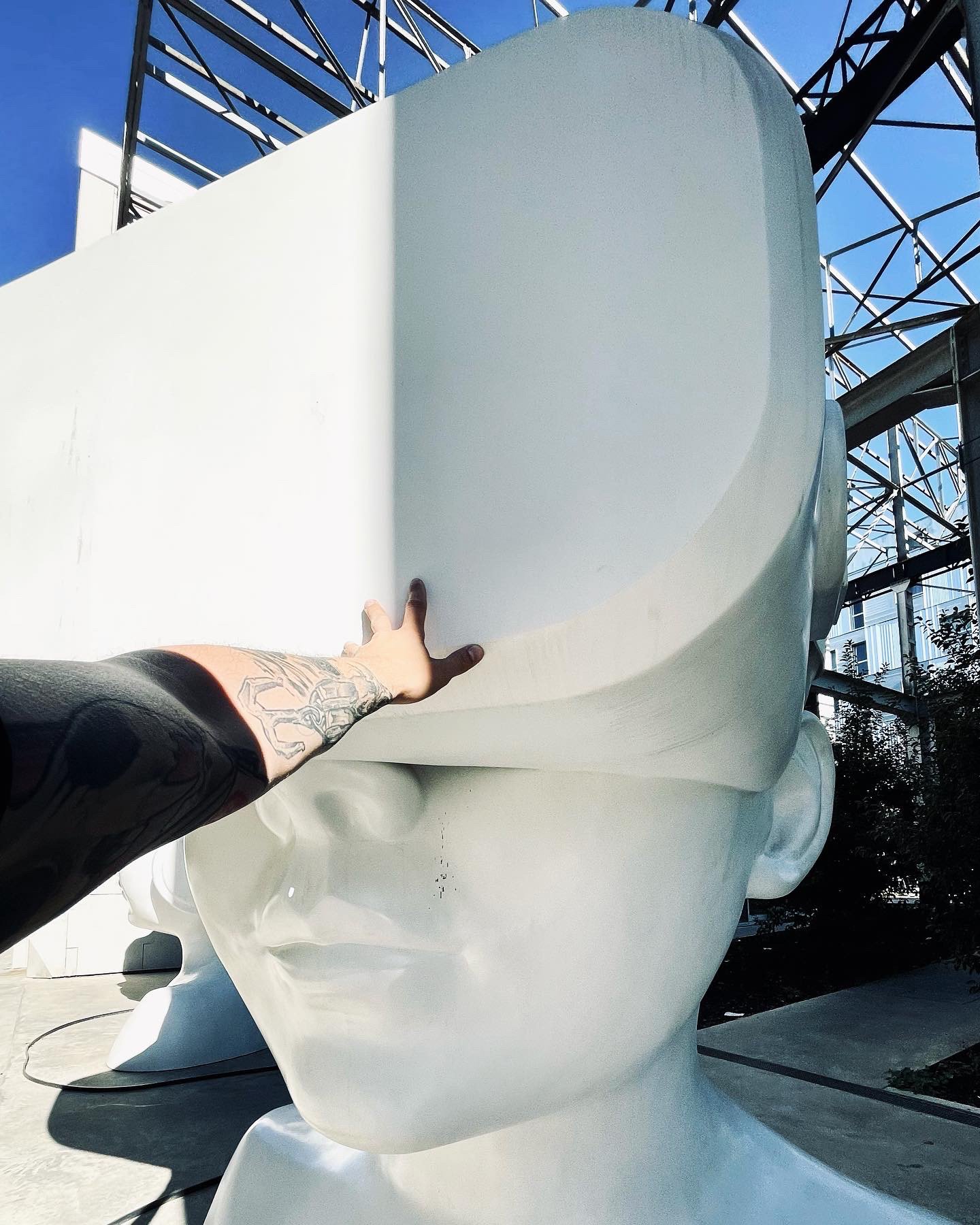 Hand touching a white sculpture head