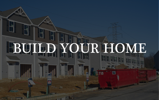 New row of townhouses under construction with a large red dumpster in front.