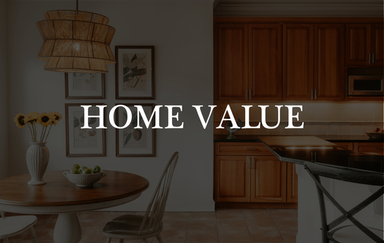 Living room and kitchen with wooden cabinets, a dining table, chairs, a vase with flowers, framed wall art, and a hanging light fixture.
