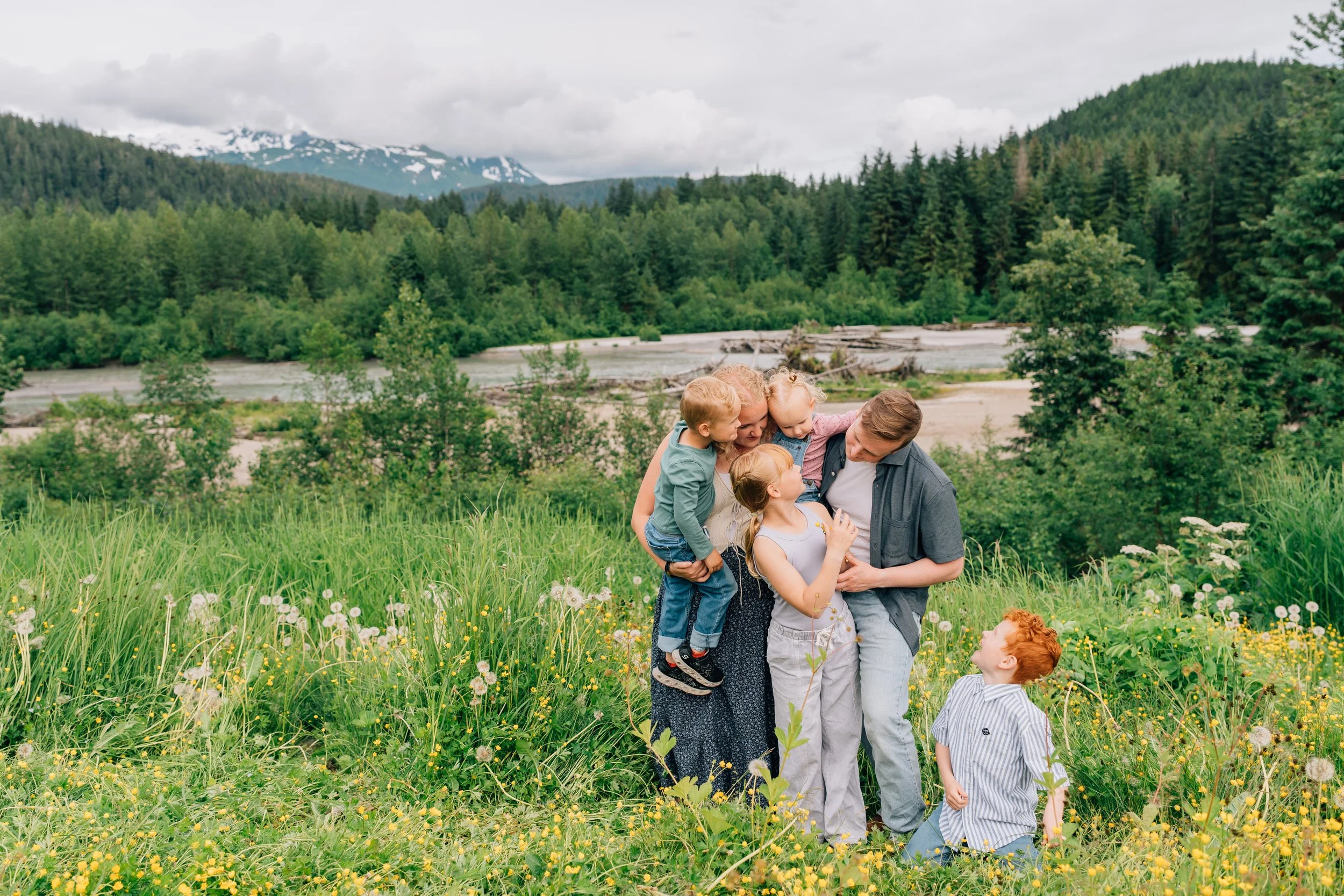 A family stands cuddled up in their juneau family photo location