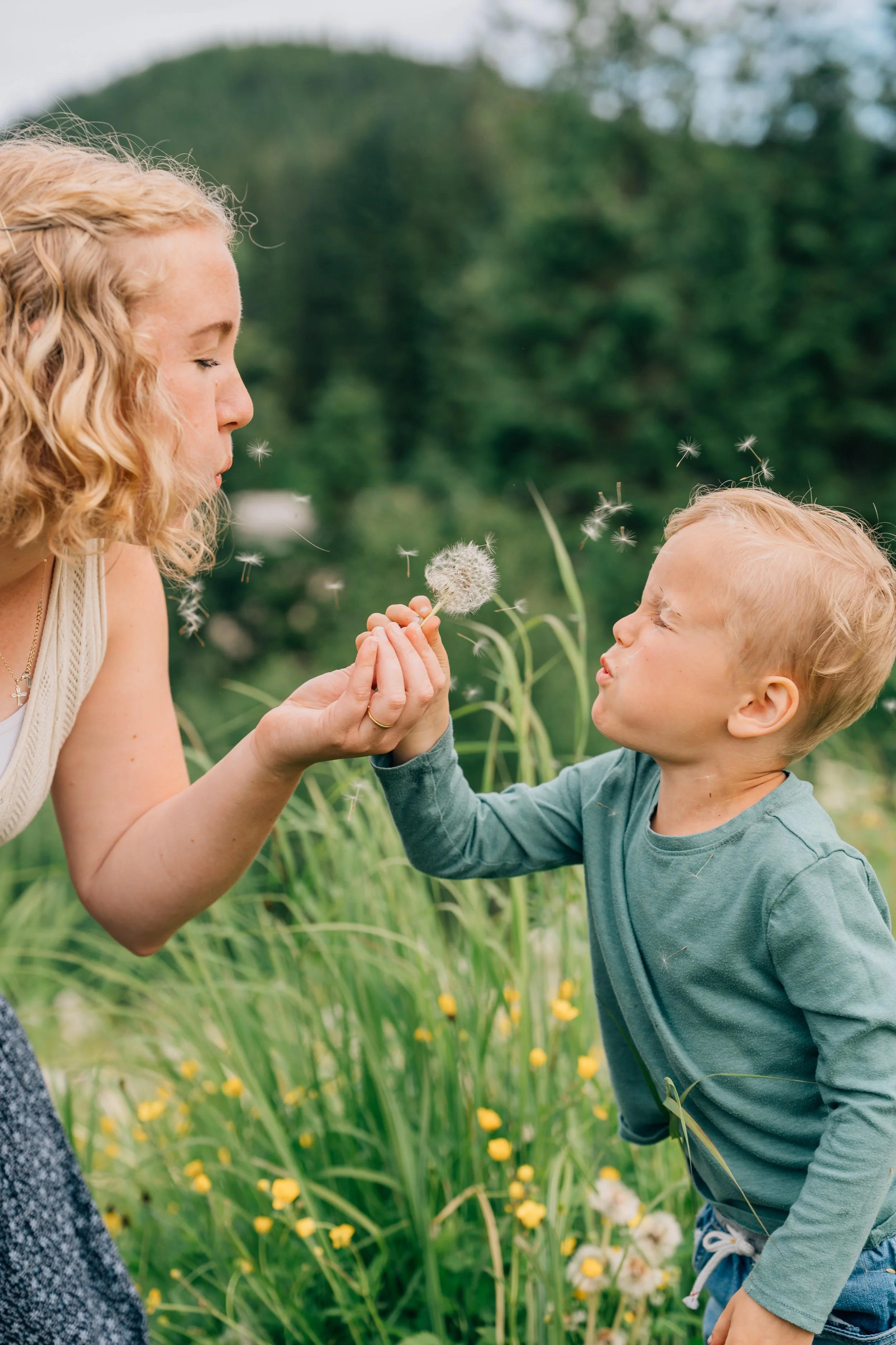 mom and son blow a dandelion at eagle beach campground in juneau