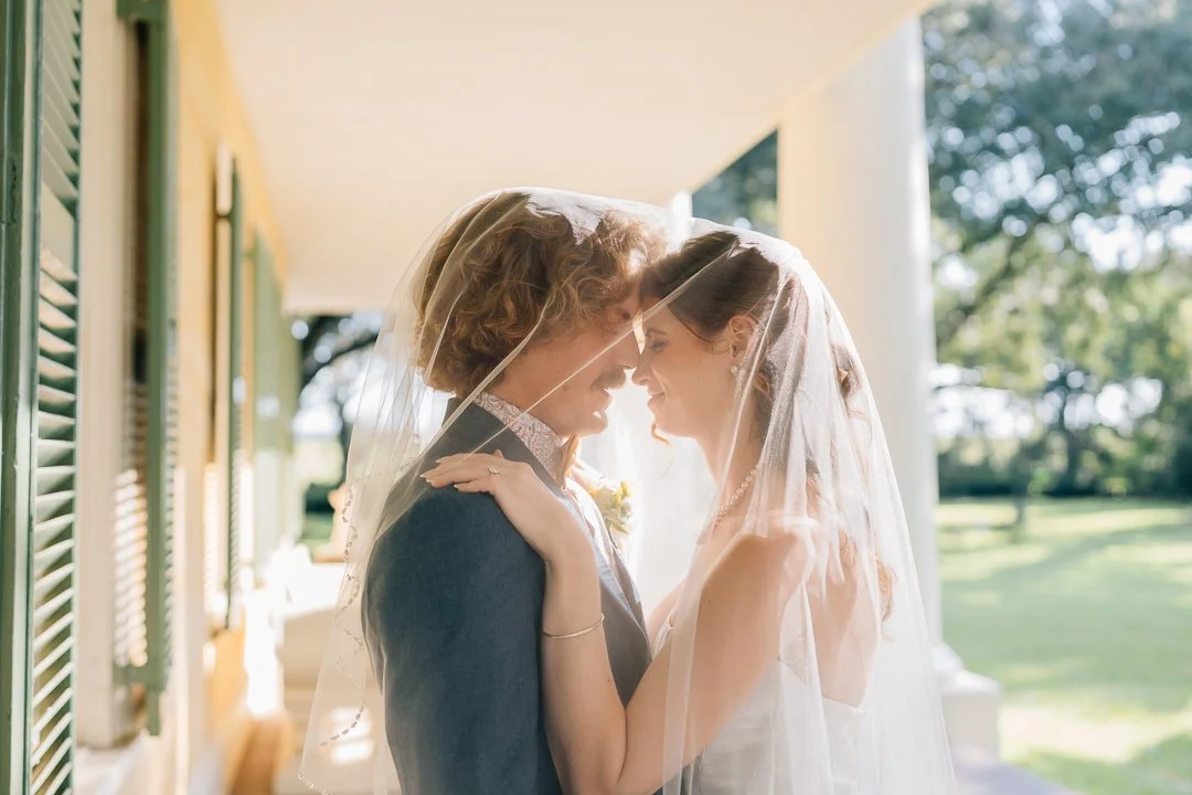 bride and groom touch noses under golden light in alaska at their elopement