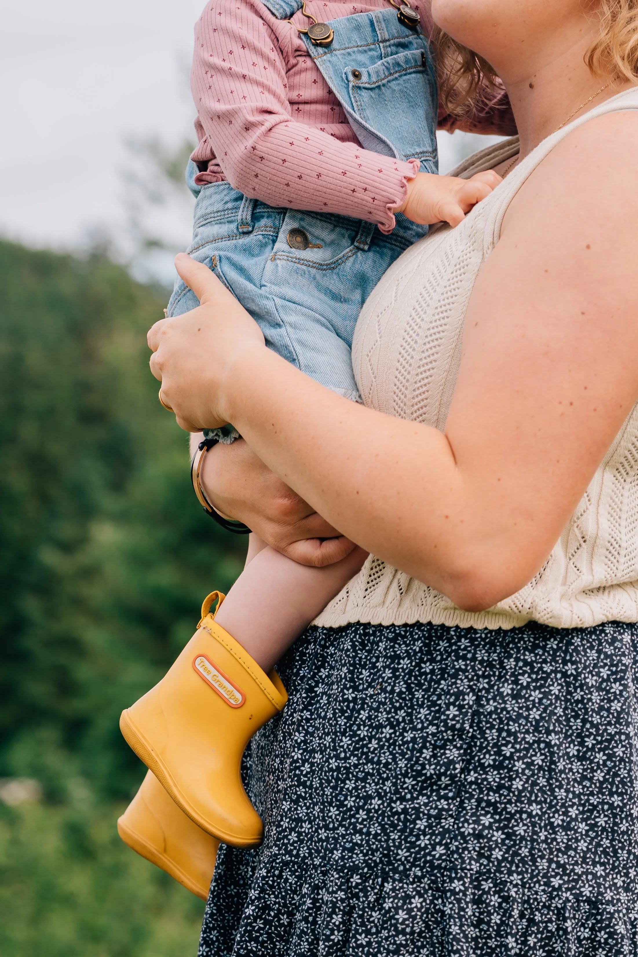 mom holds baby in rain boots in Juneau Alaska