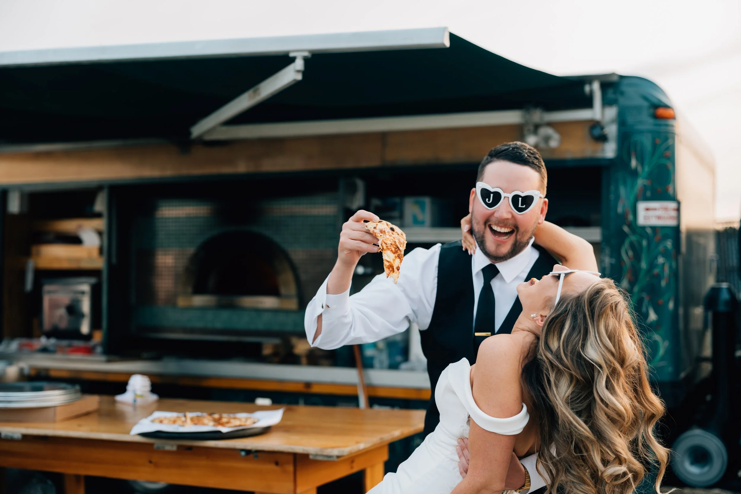groom feeds bride pizza at their elopement in juneau