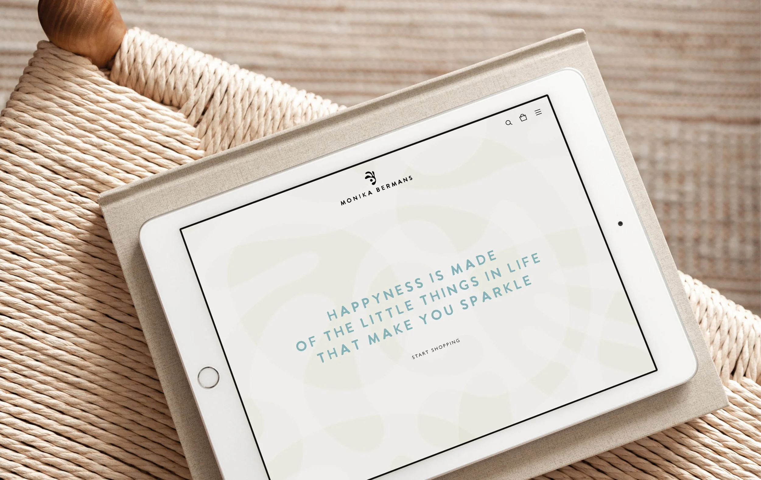 Close-up of a white tablet displaying a motivational quote on a web page, placed on a padded surface with a woven rope underneath.